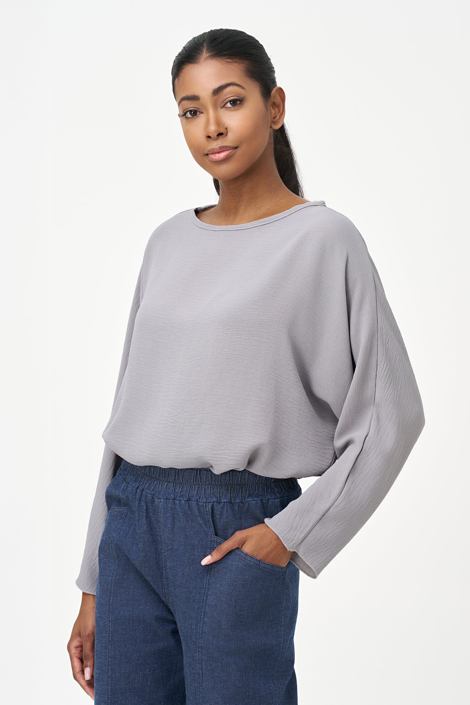 Grey long sleeve blouse with wide neckline and relaxed cropped fit.
