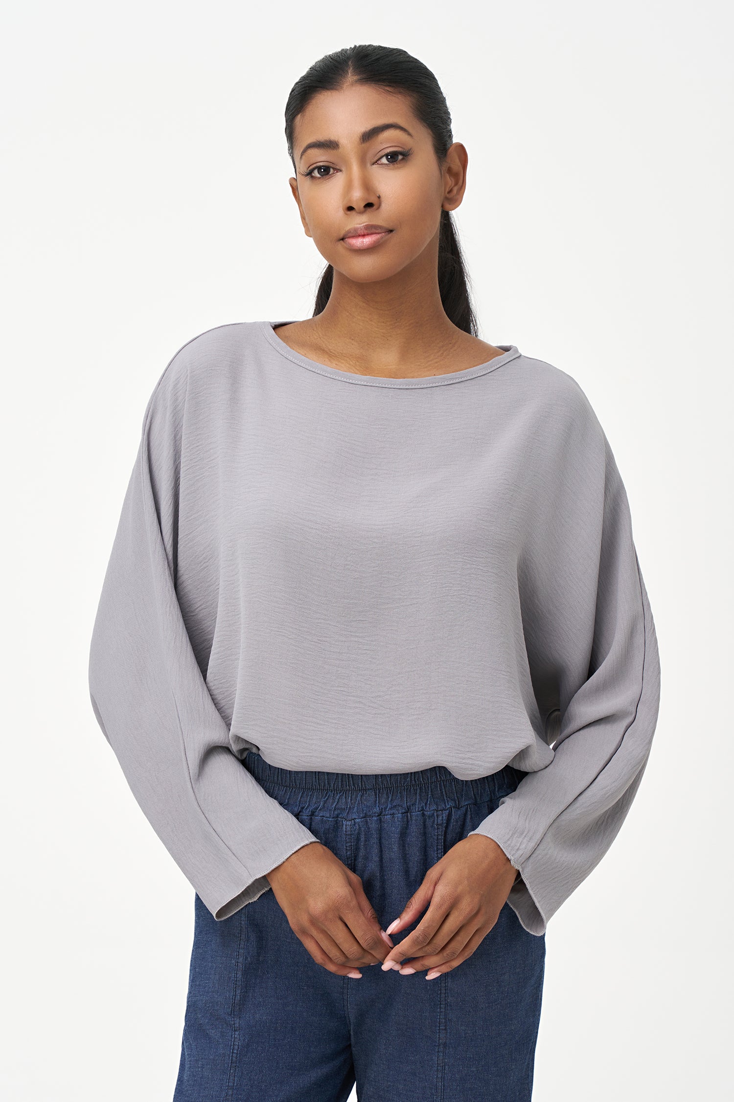 Grey long sleeve blouse with wide neckline and relaxed cropped fit.