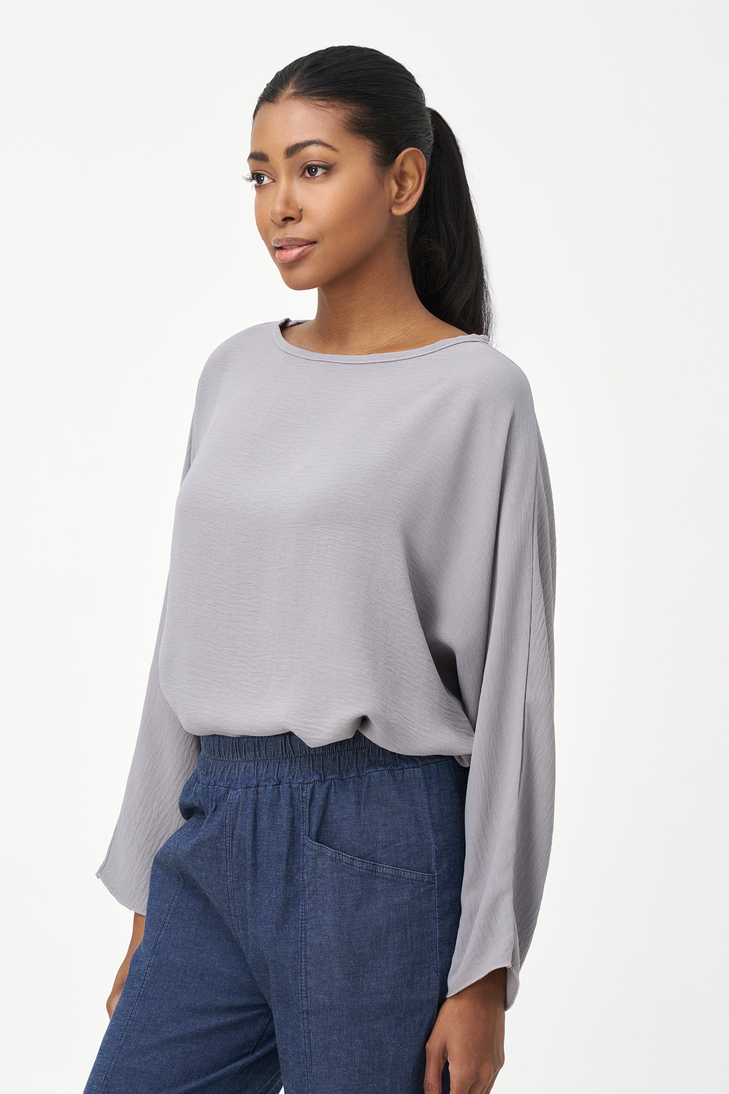Grey long sleeve blouse with wide neckline and relaxed cropped fit.