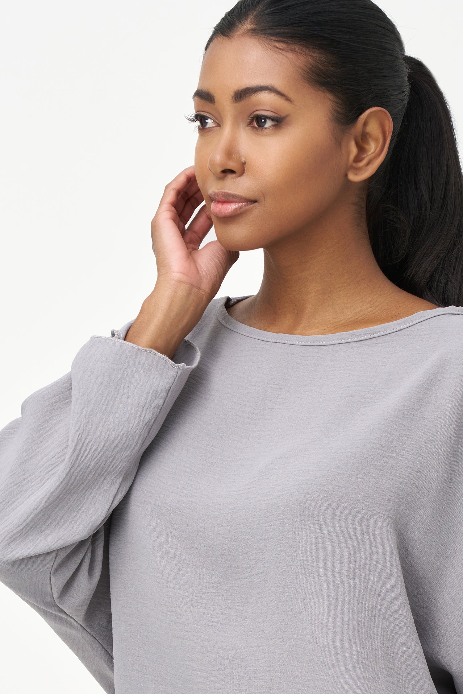 Grey long sleeve blouse with wide neckline and relaxed cropped fit.