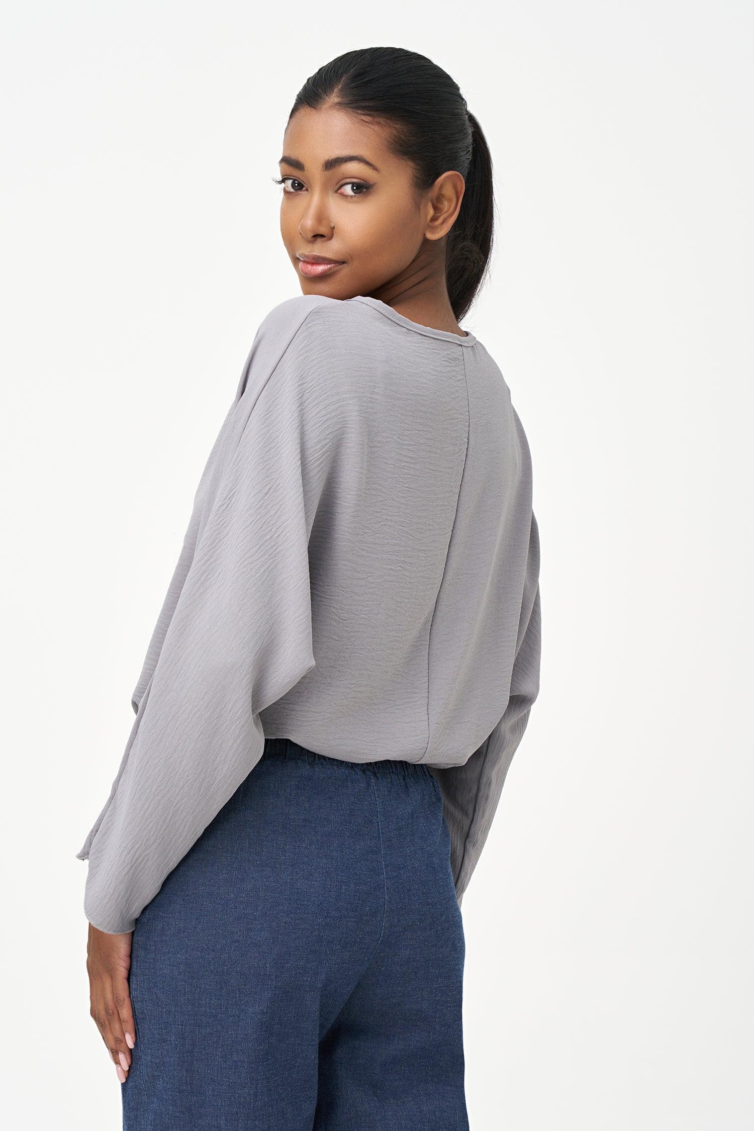 Grey long sleeve blouse with wide neckline and relaxed cropped fit.