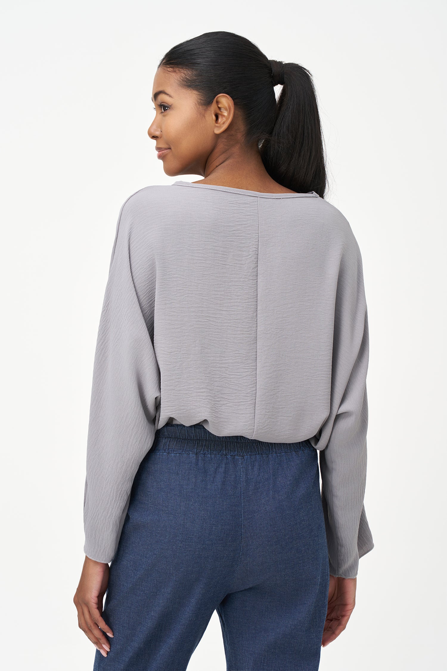 Grey long sleeve blouse with wide neckline and relaxed cropped fit.