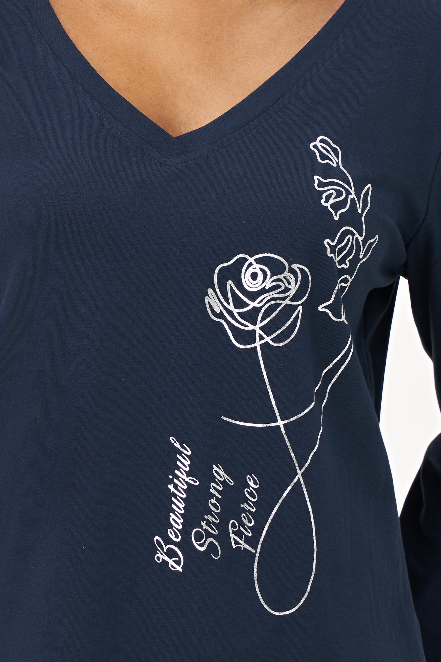 Blue V-neck long-sleeve top with white embroidered floral design and cursive script reading 'Beautiful, Bonjour, Fleur' on the front.