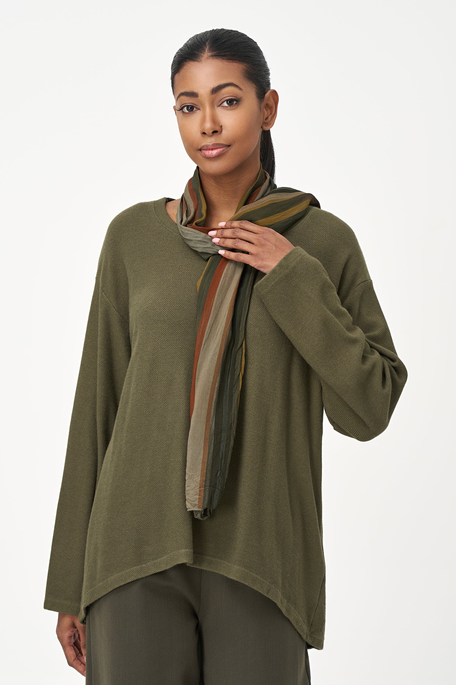Olive green long sleeve top with a rounded hem and attached multicolor striped scarf, perfect for fall layering.