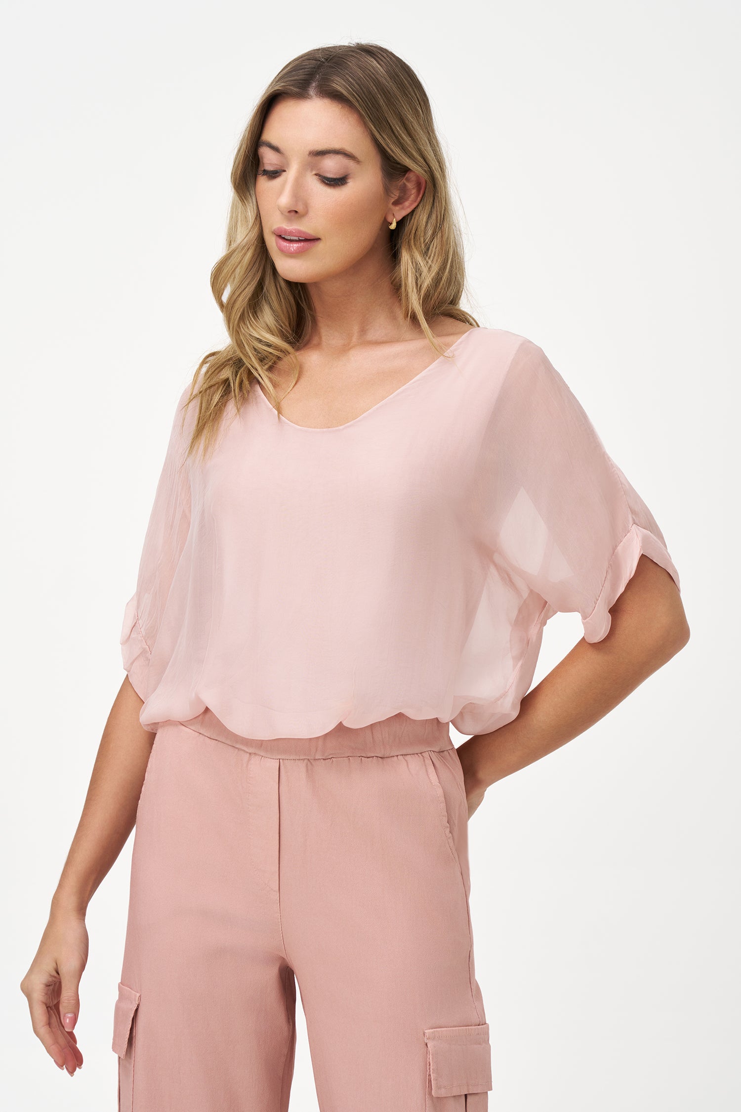 Light beige short sleeve sheer blouse with relaxed fit and soft round neckline.