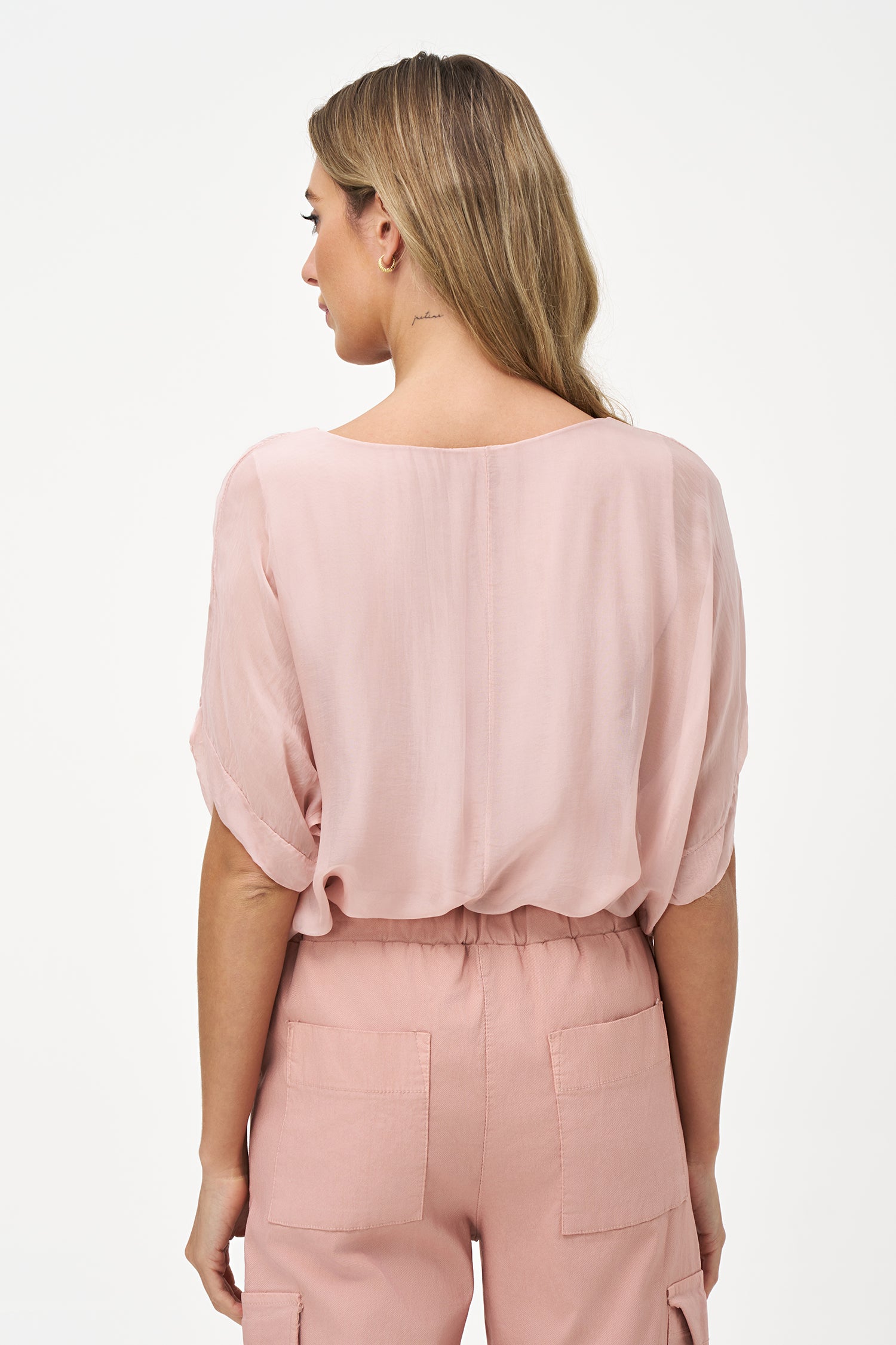 Light beige short sleeve sheer blouse with relaxed fit and soft round neckline.