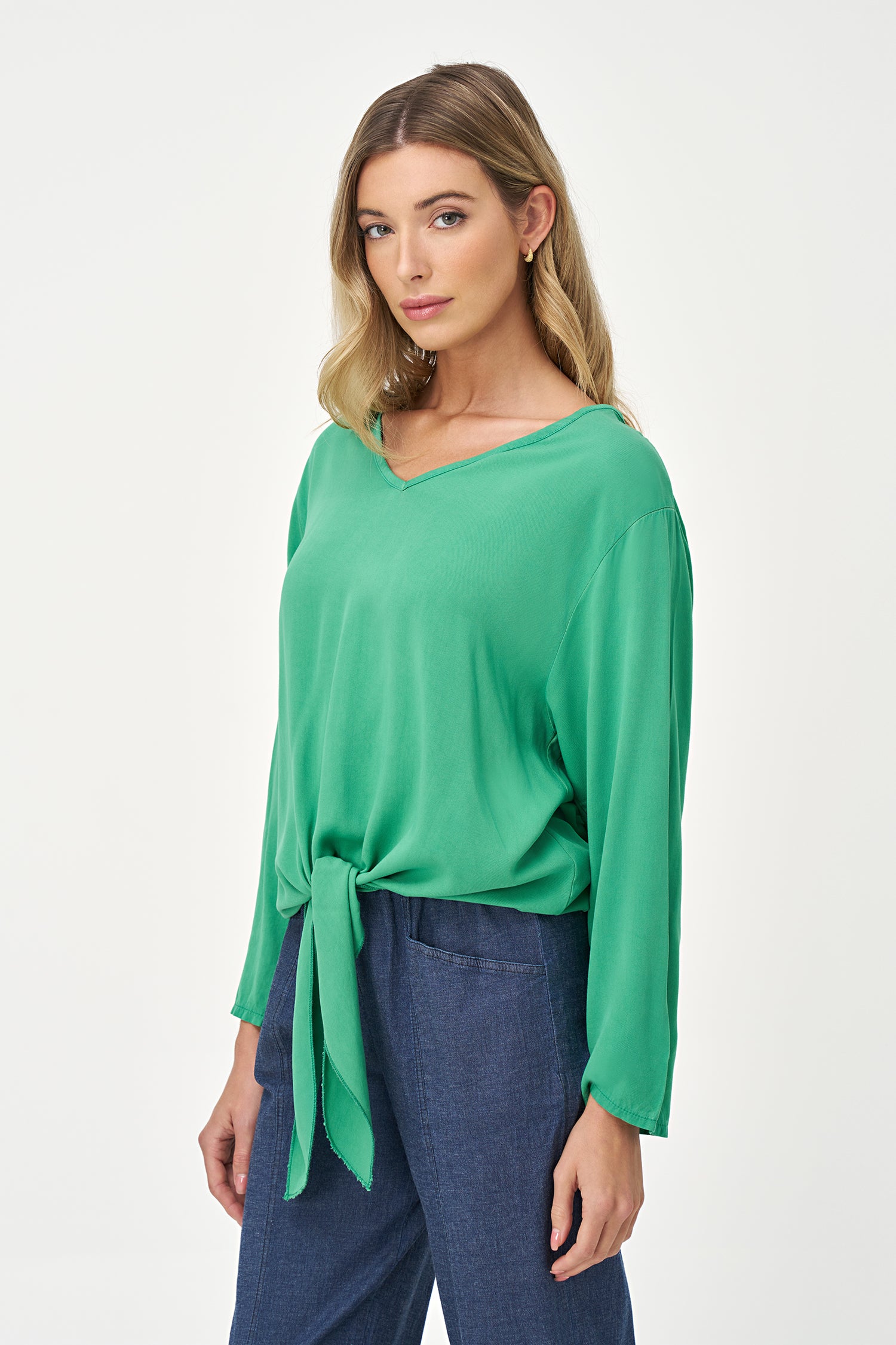 Green V-neck long sleeve top with front tie detail and relaxed silhouette.