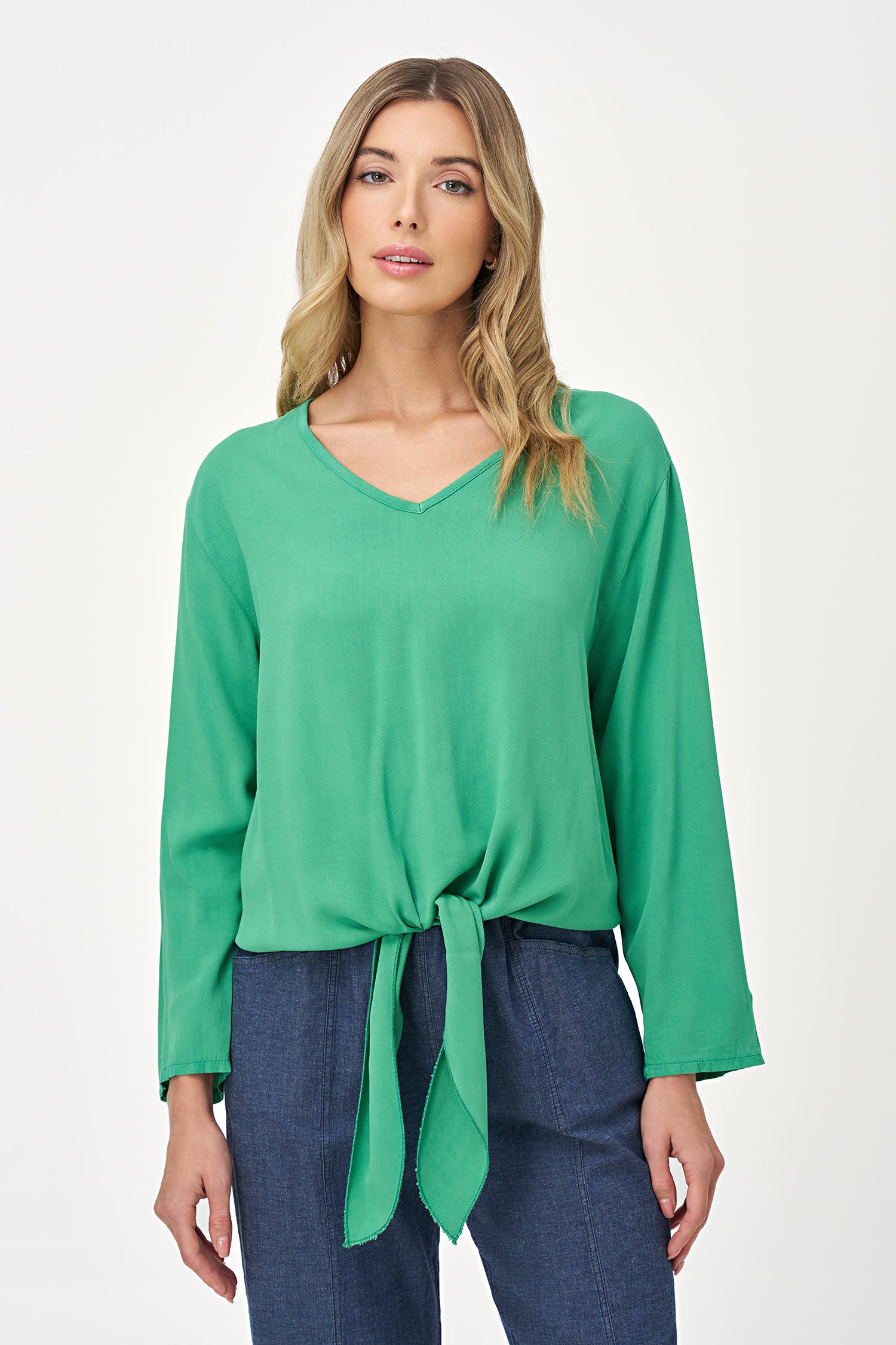Green V-neck long sleeve top with front tie detail and relaxed silhouette.