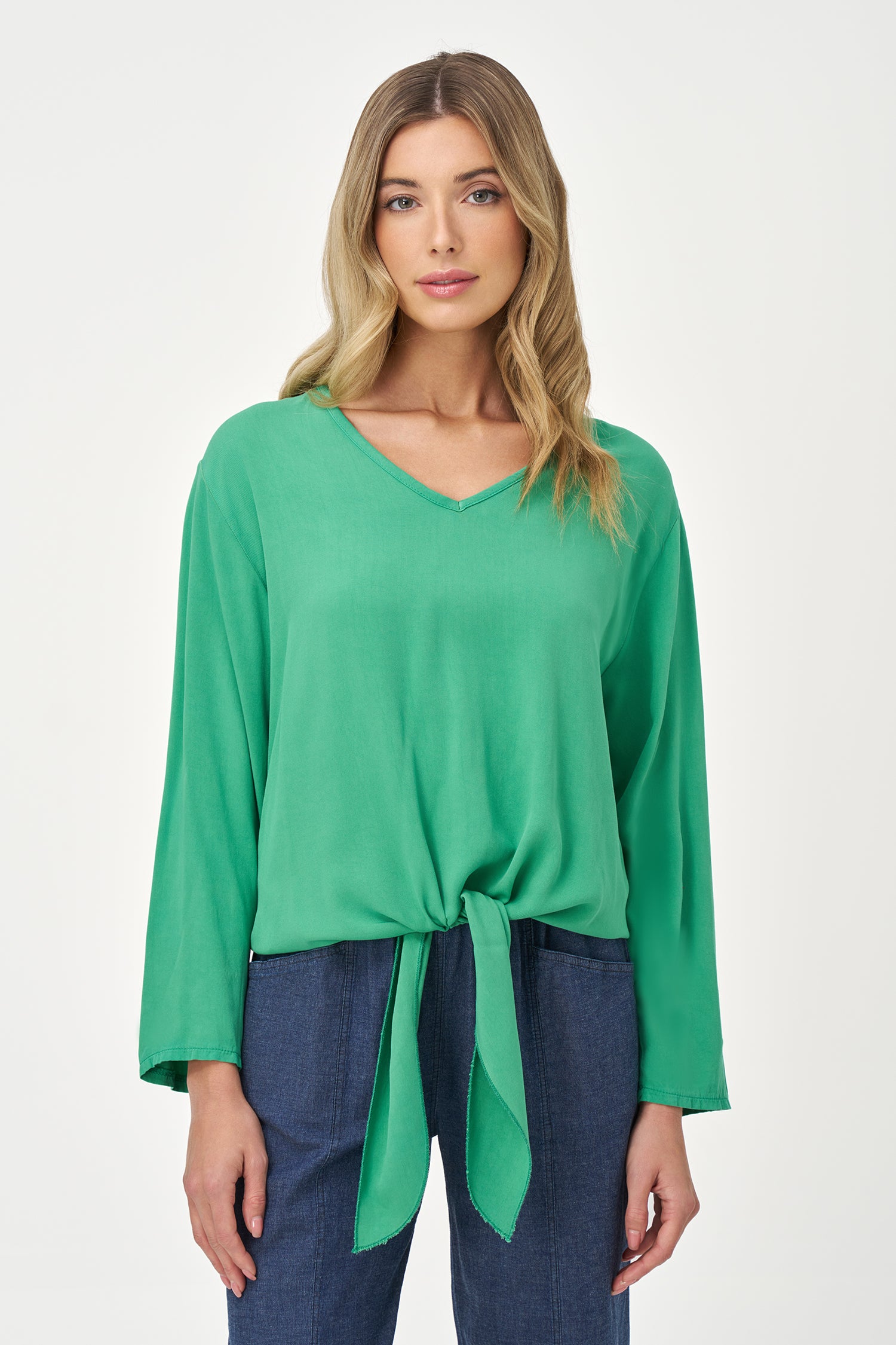 Green V-neck long sleeve top with front tie detail and relaxed silhouette.
