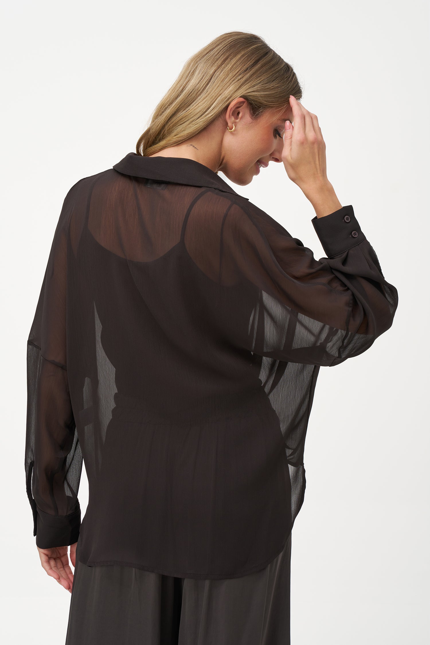Brown sheer long-sleeve blouse with draped crossover front and inner tank layer