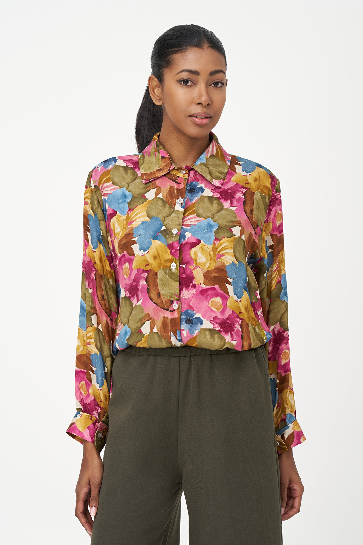 Long-sleeve button-up blouse with colorful floral print in fall season tones on pink background