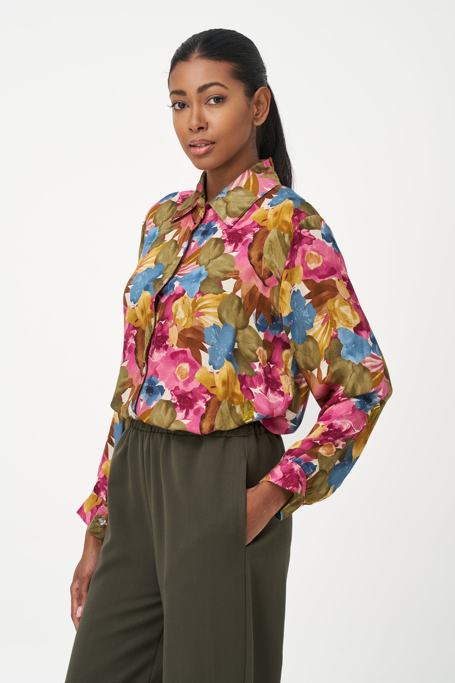Long-sleeve button-up blouse with colorful floral print in fall season tones on pink background