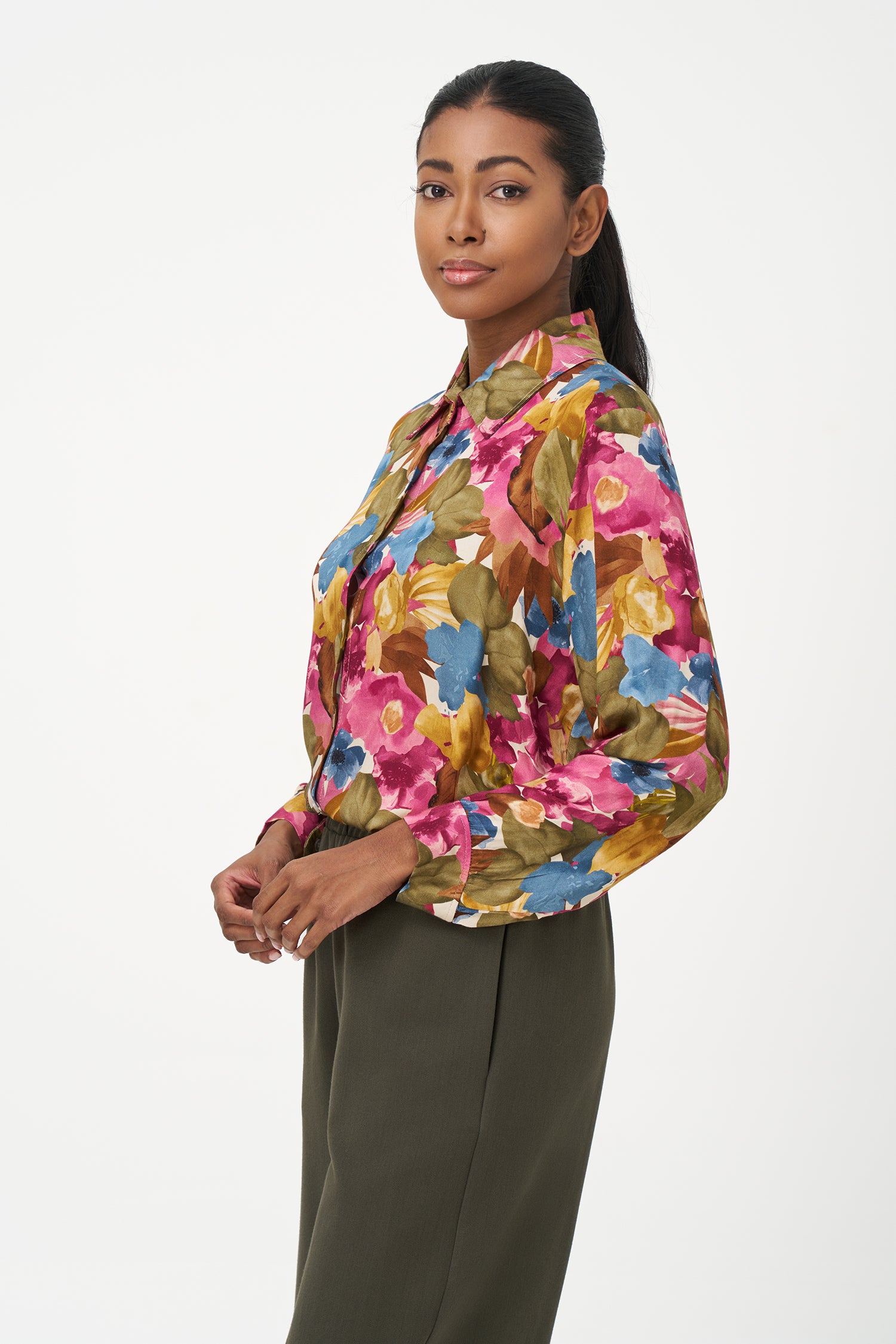 Long-sleeve button-up blouse with colorful floral print in fall season tones on pink background