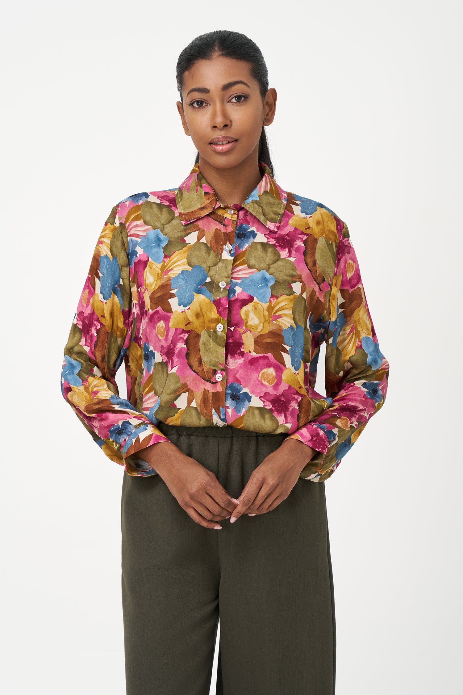 Long-sleeve button-up blouse with colorful floral print in fall season tones on pink background