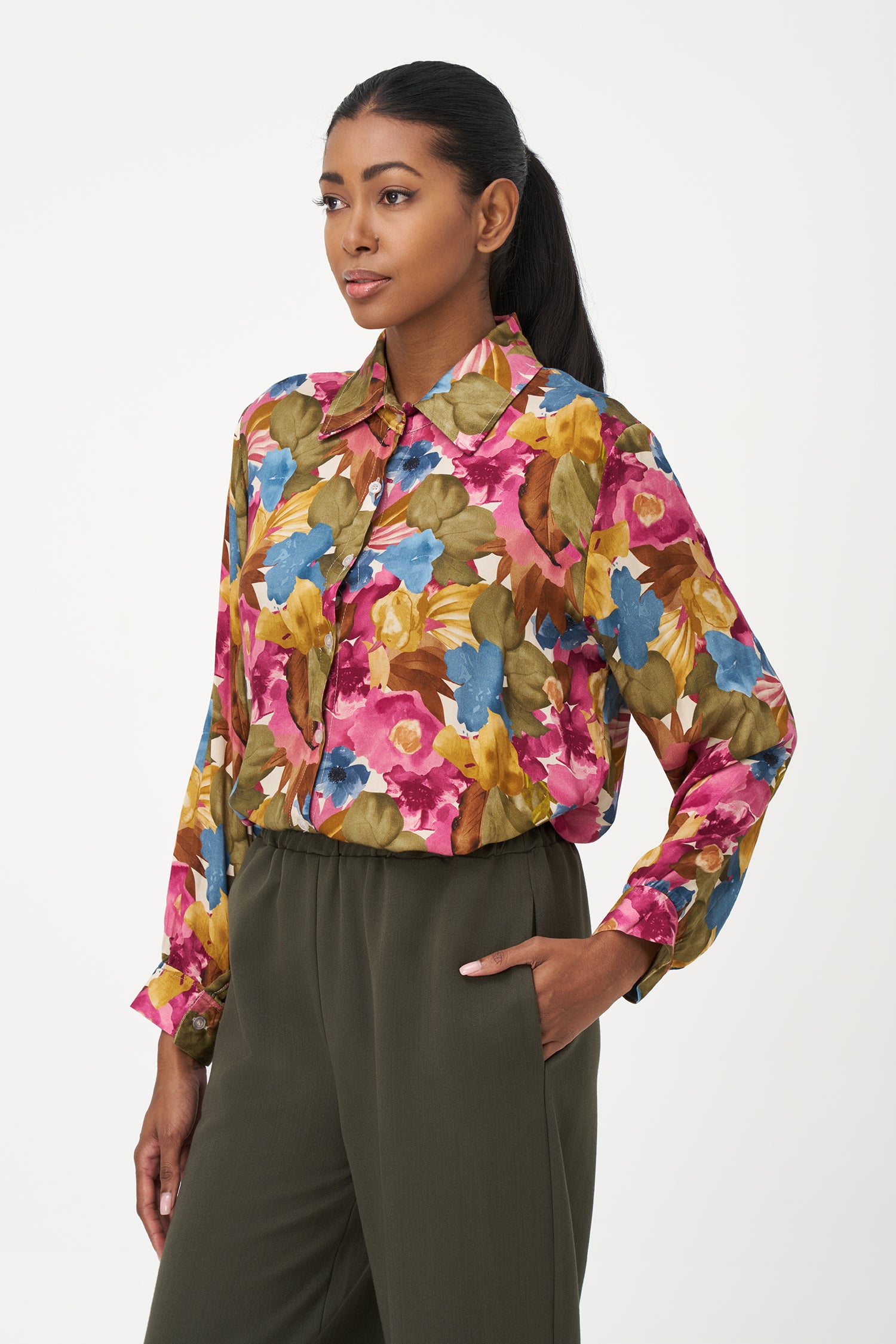 Long-sleeve button-up blouse with colorful floral print in fall season tones on pink background