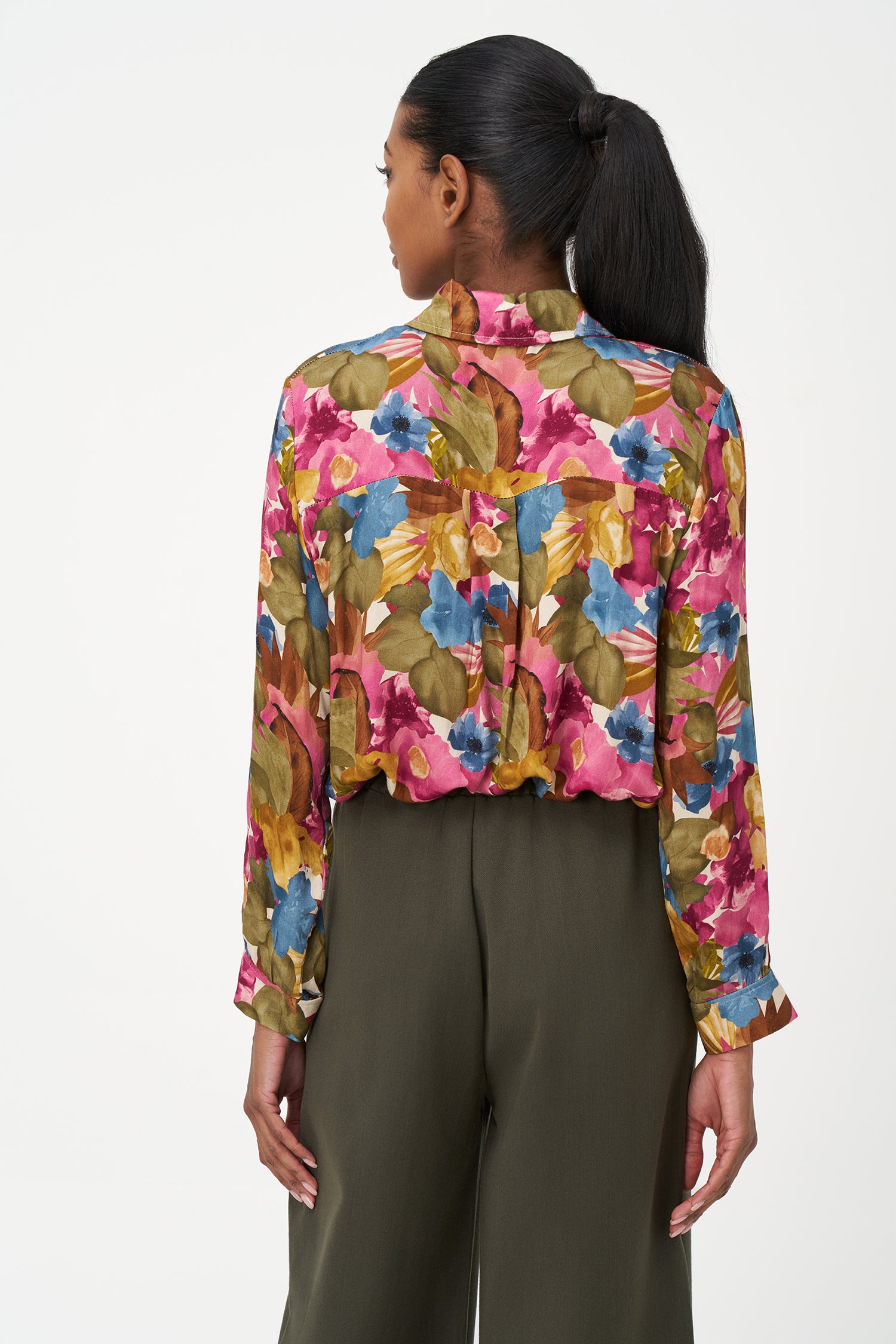 Long-sleeve button-up blouse with colorful floral print in fall season tones on pink background