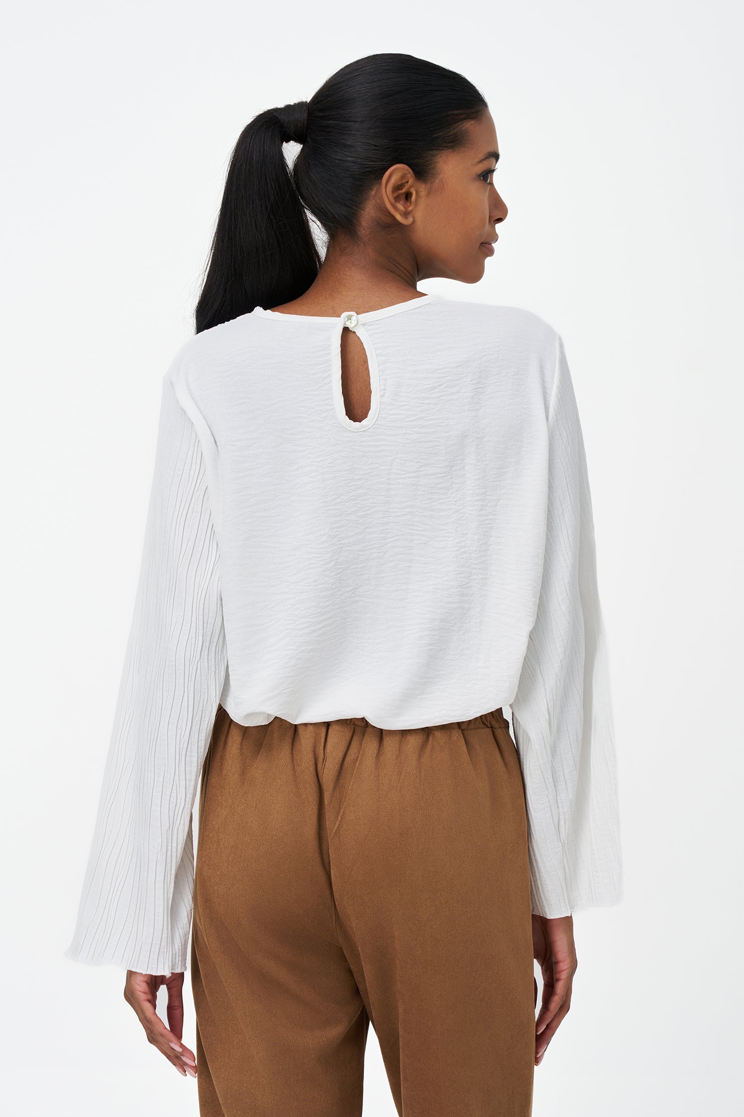 White crinkled long sleeve blouse with round neckline and back keyhole closure.