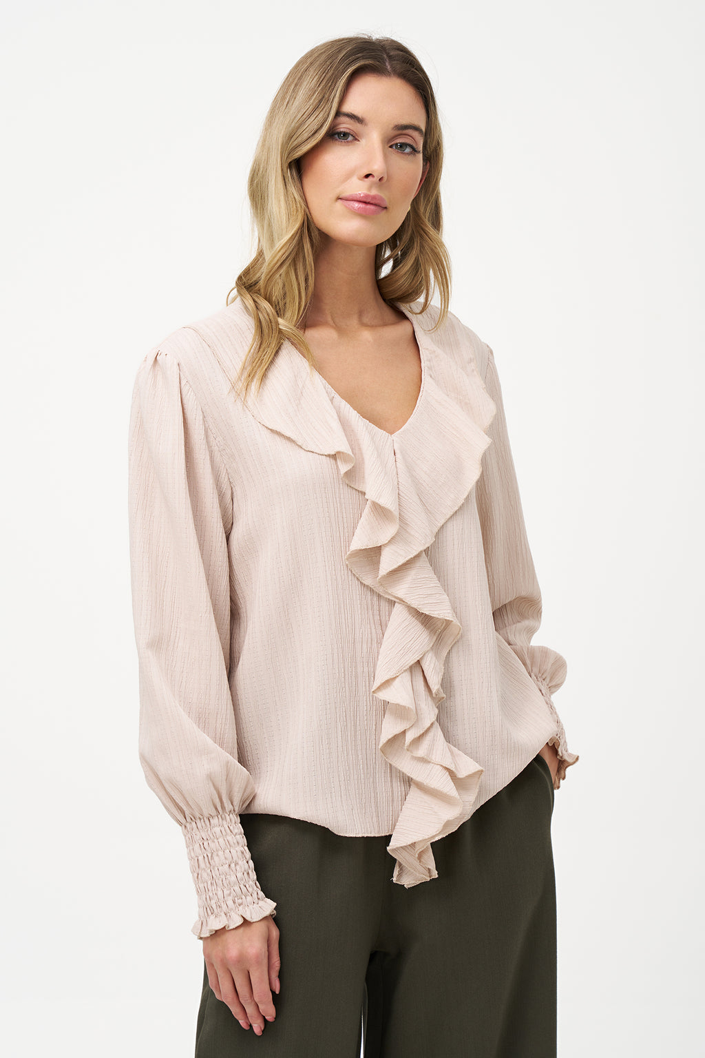 Elegant white long-sleeve blouse with vertical pleats, dramatic front ruffle, and smocked cuffs.