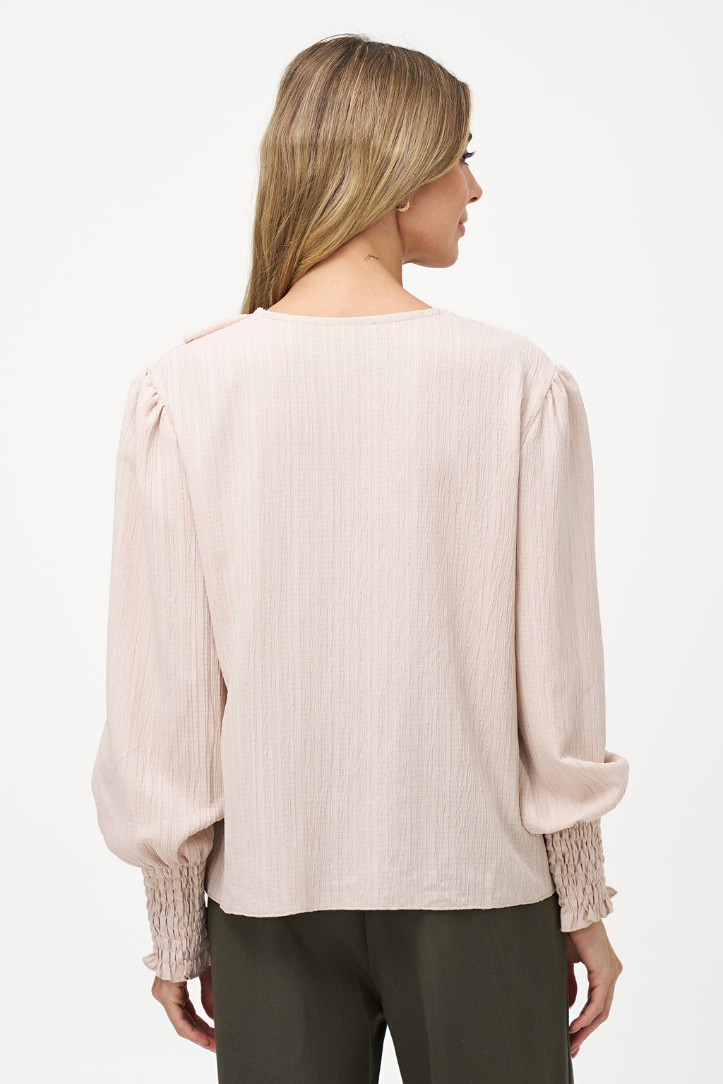 Elegant white long-sleeve blouse with vertical pleats, dramatic front ruffle, and smocked cuffs.
