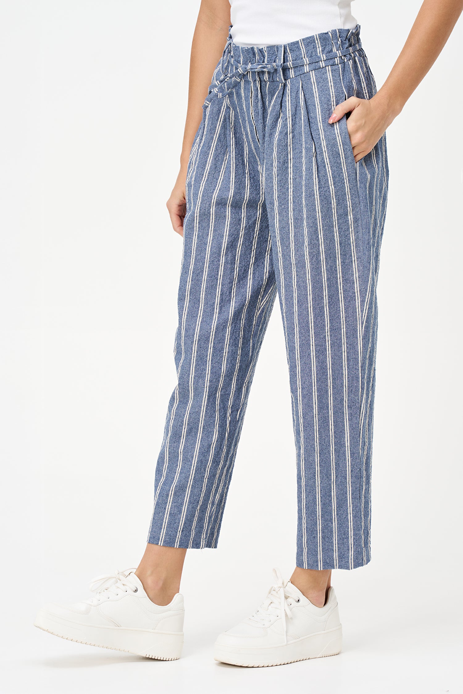 Blue striped cotton pants with tie-waist detail, cropped ankle length, and a tailored yet relaxed silhouette.