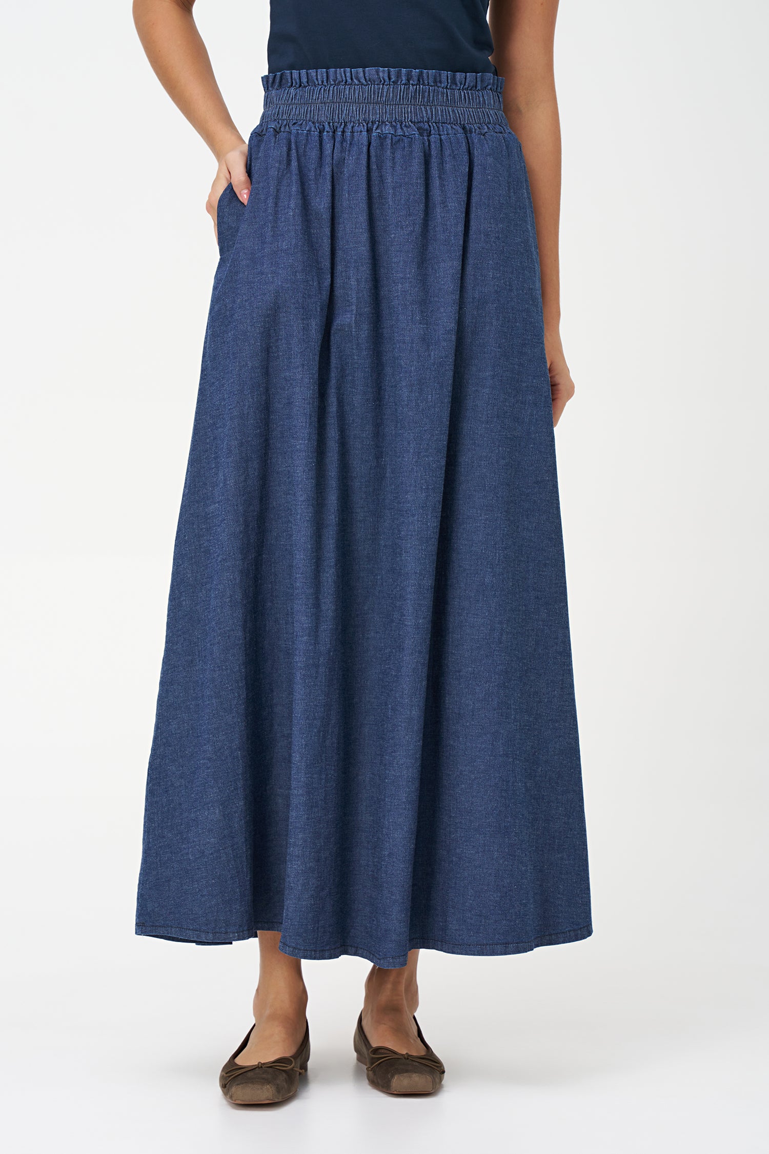 Navy denim maxi skirt in 100% cotton with a gathered elastic waistband and a soft A-line silhouette for casual elegance.