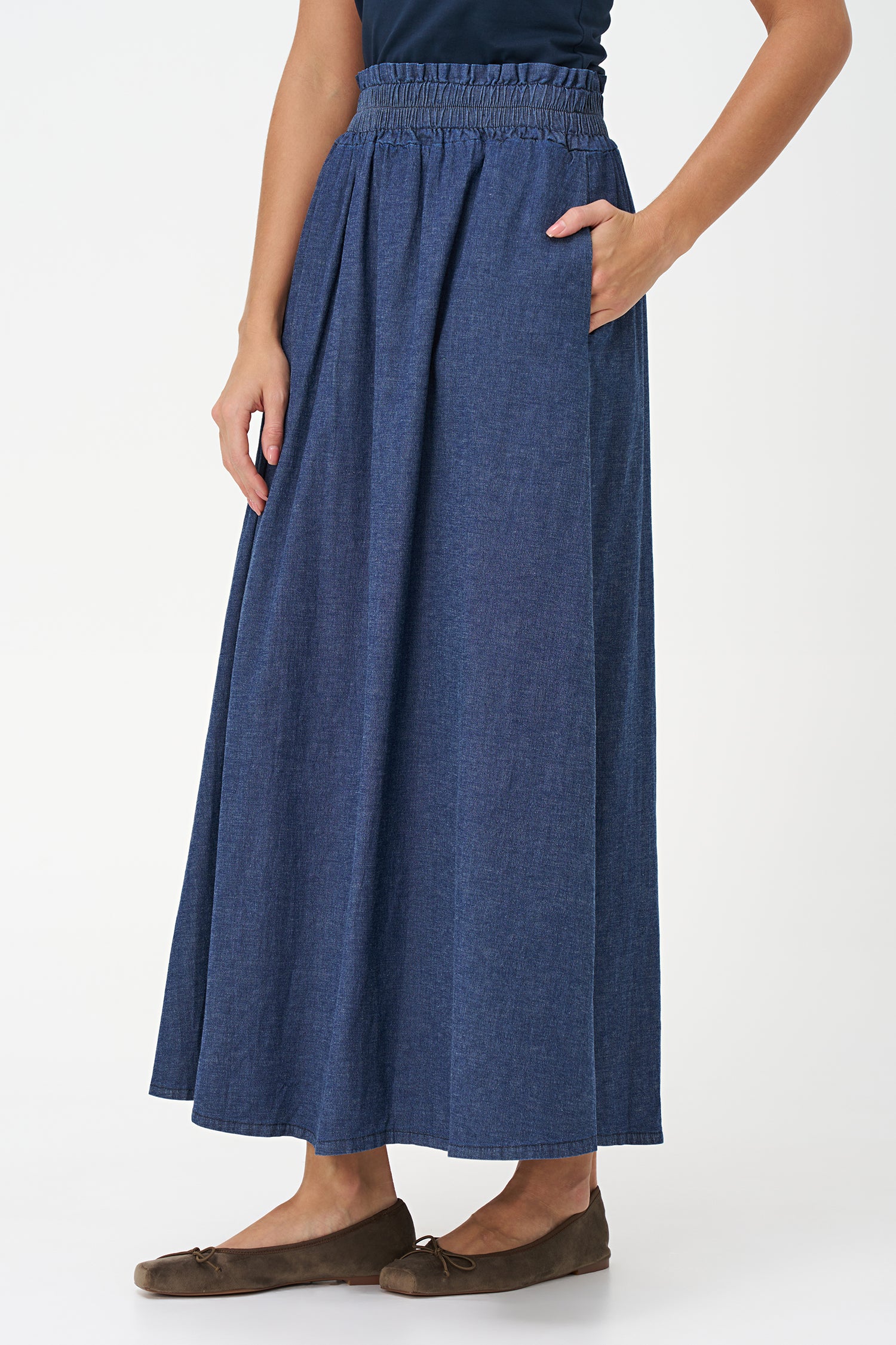 Navy denim maxi skirt in 100% cotton with a gathered elastic waistband and a soft A-line silhouette for casual elegance.