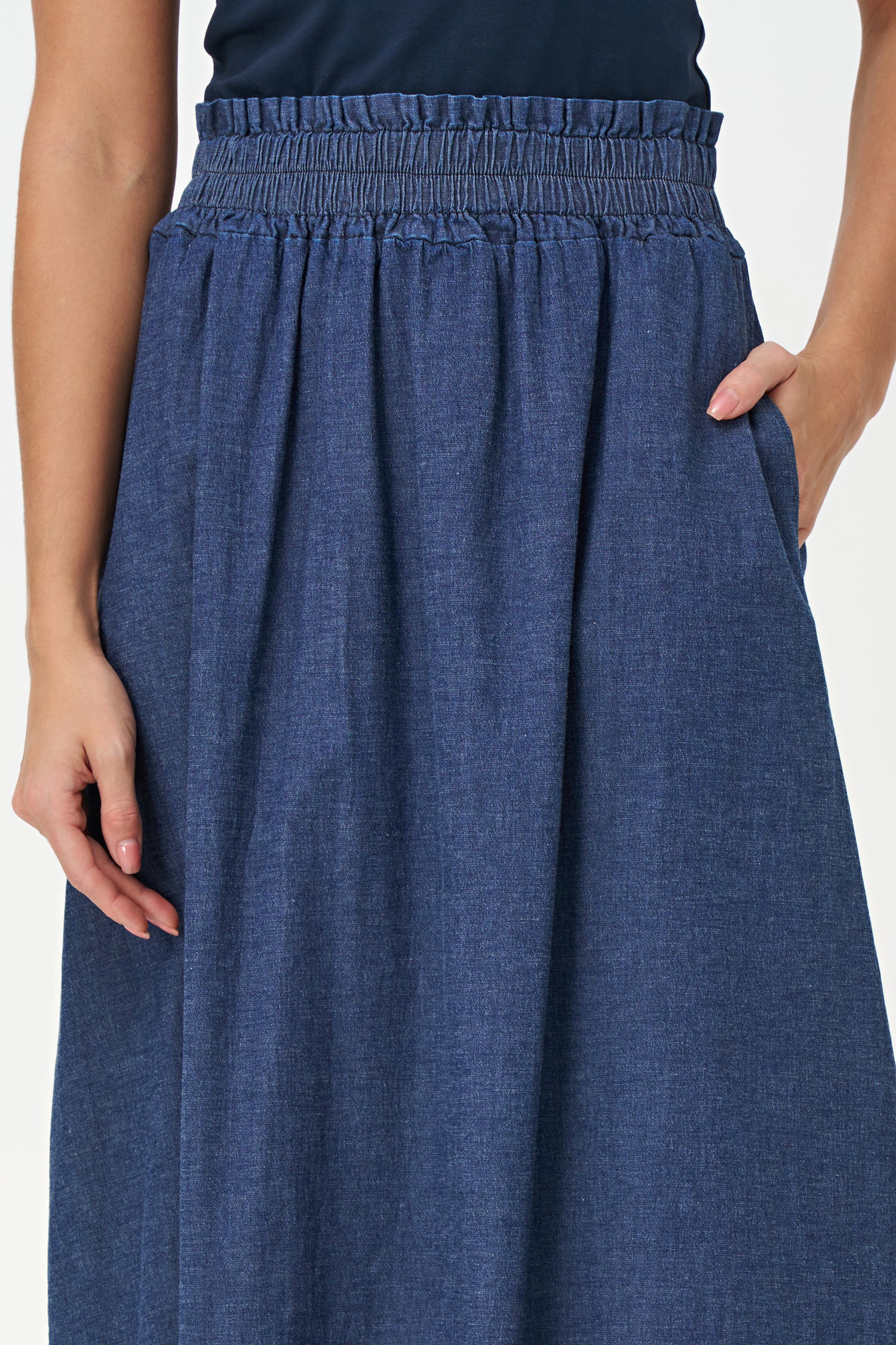Navy denim maxi skirt in 100% cotton with a gathered elastic waistband and a soft A-line silhouette for casual elegance.