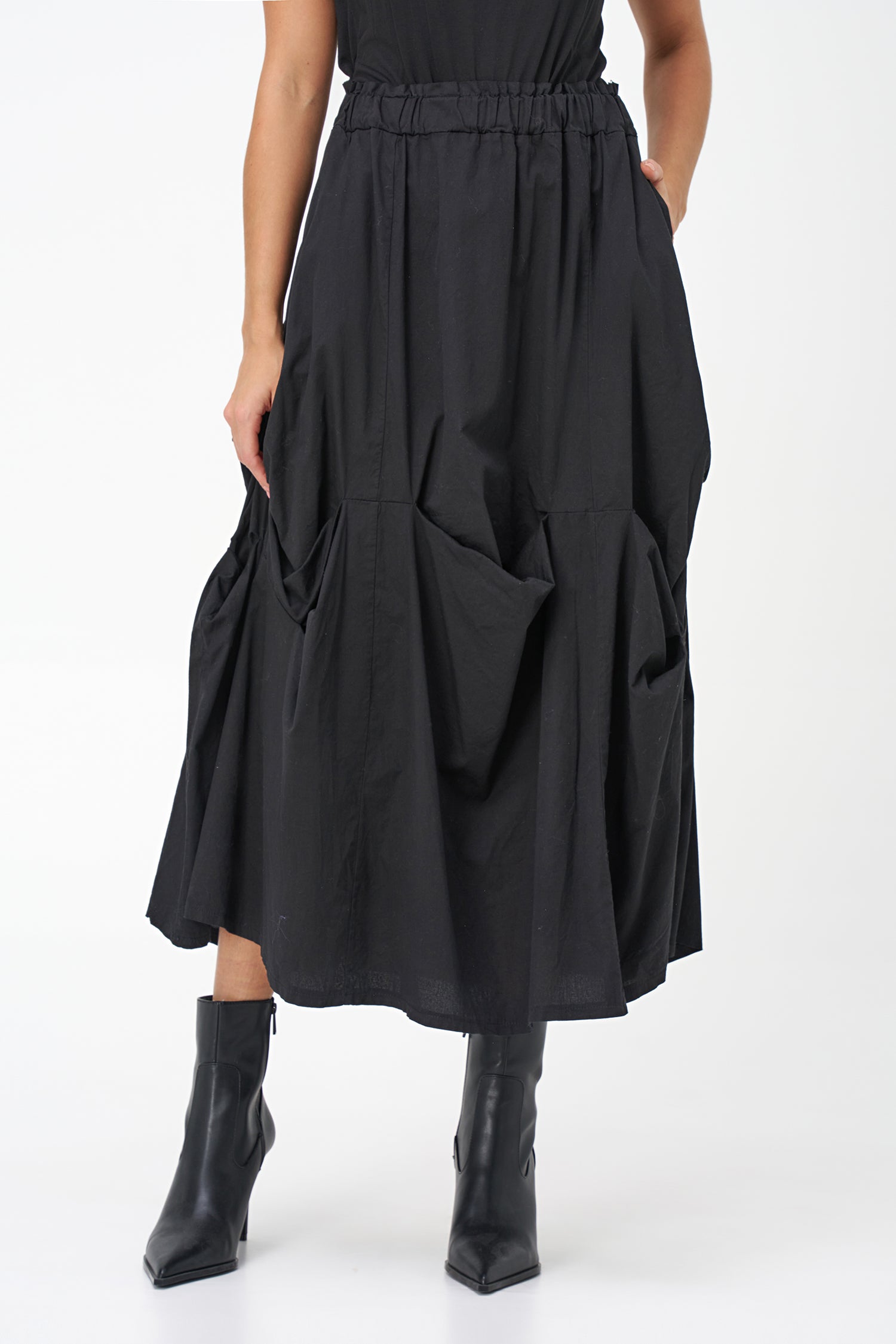 Black cotton midi skirt with unique gathered pocket detailing and elastic waistband, combining comfort with avant-garde flair.