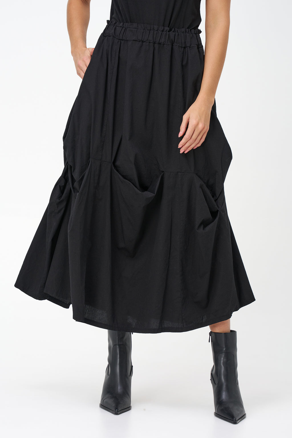 Black cotton midi skirt with unique gathered pocket detailing and elastic waistband, combining comfort with avant-garde flair.