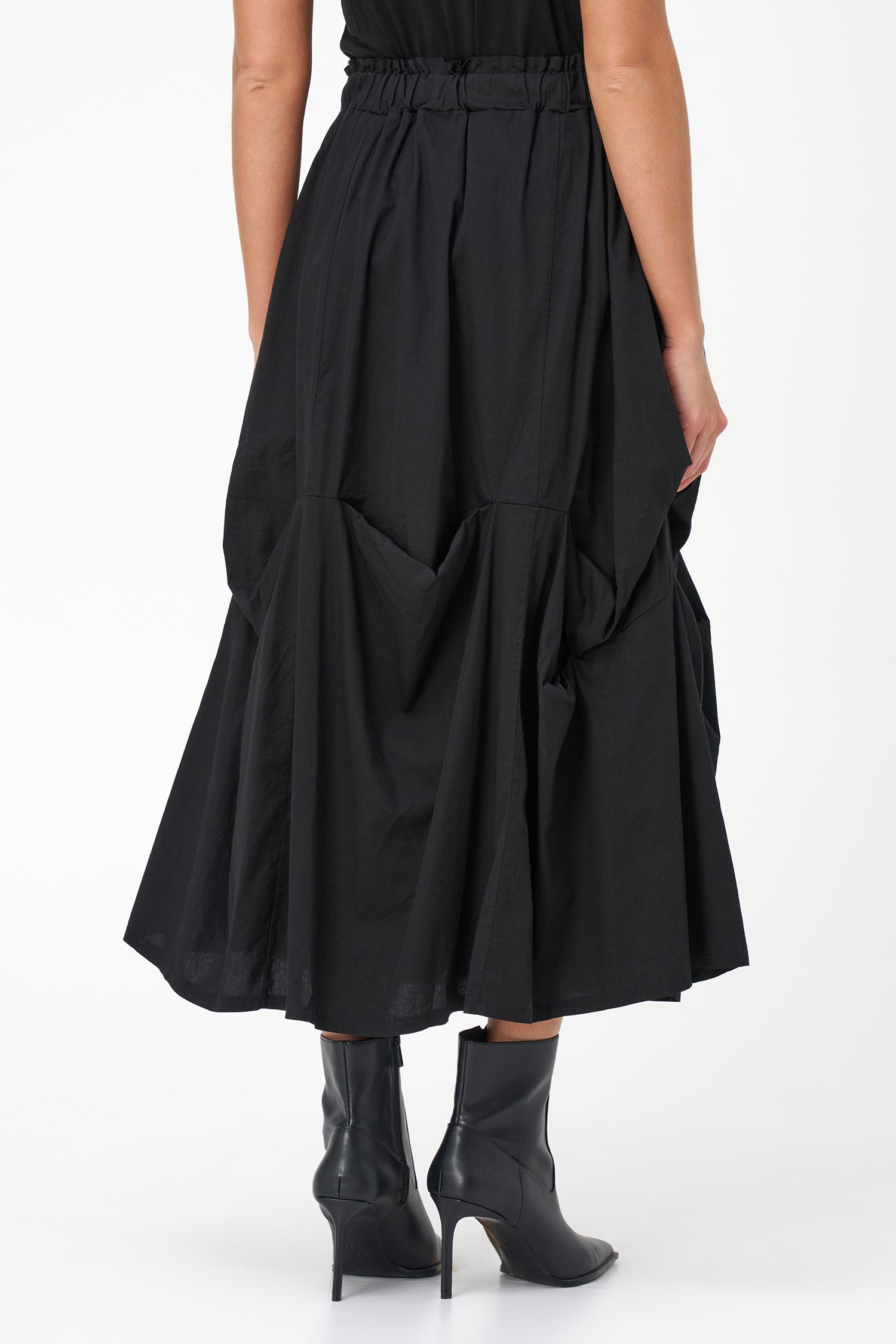 Black cotton midi skirt with unique gathered pocket detailing and elastic waistband, combining comfort with avant-garde flair.
