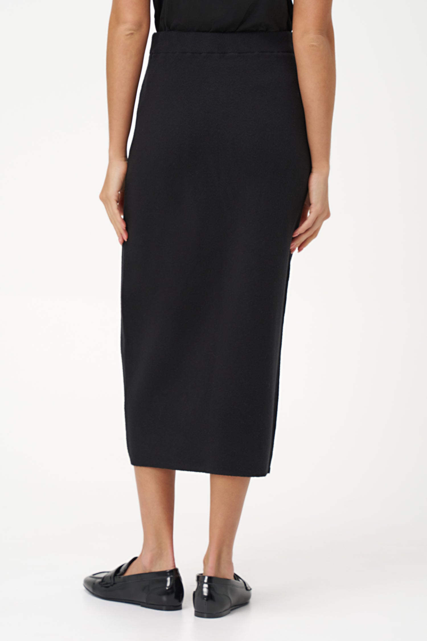 Black knit pencil skirt with front contrast seam detail, crafted in soft stretch rayon blend for a sleek, modern silhouette.