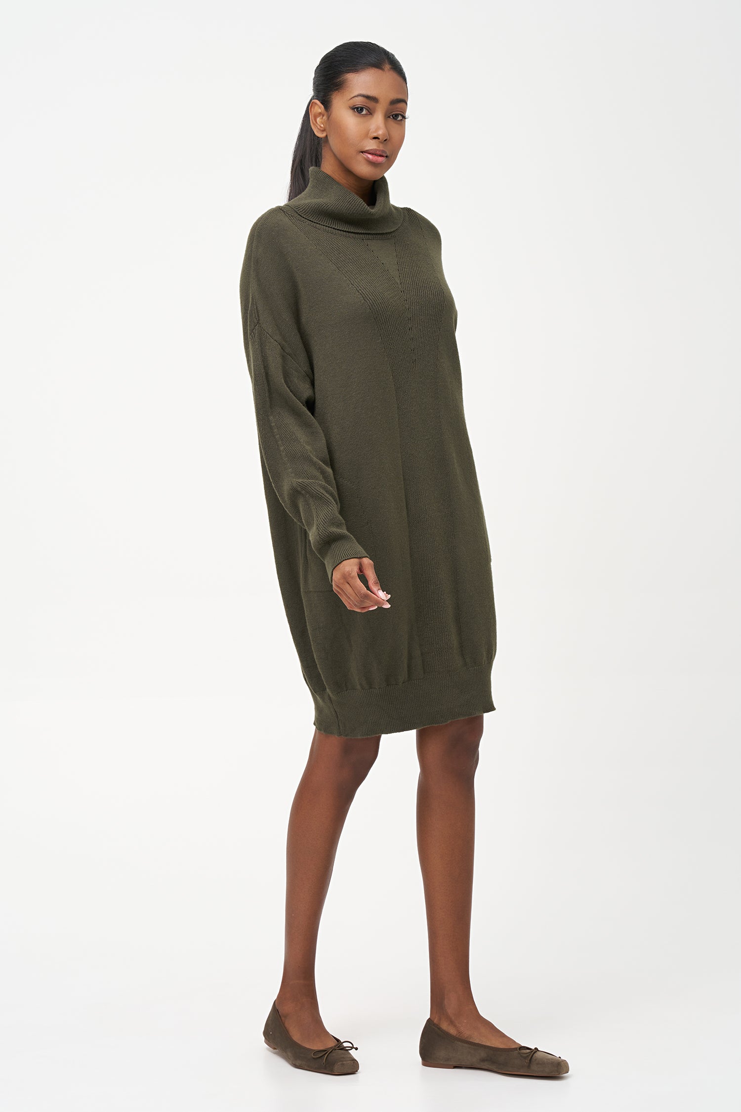 Green-colored knit turtleneck sweater dress with ribbed front panel and long sleeves for a cozy, elegant winter look.