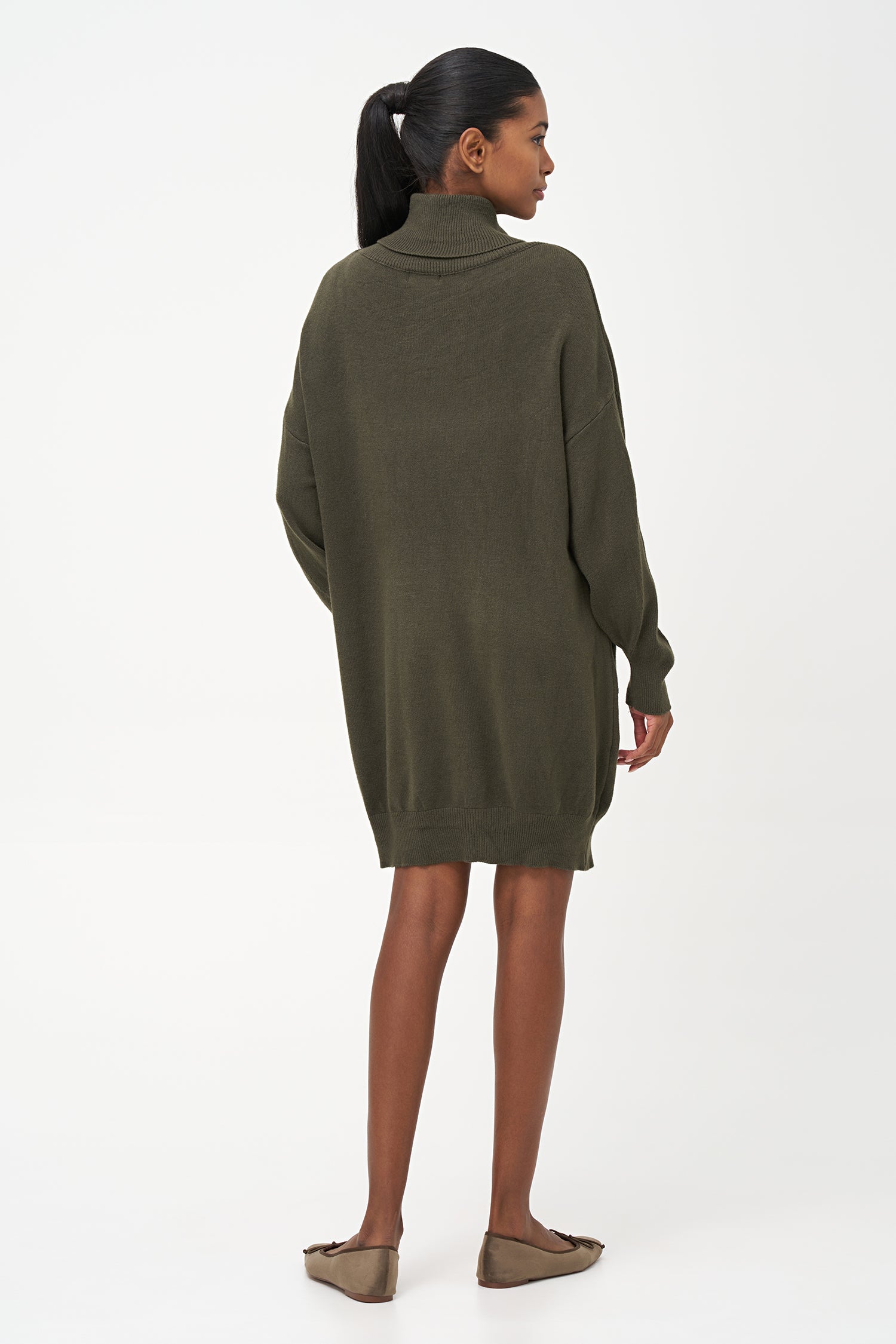 Green-colored knit turtleneck sweater dress with ribbed front panel and long sleeves for a cozy, elegant winter look.