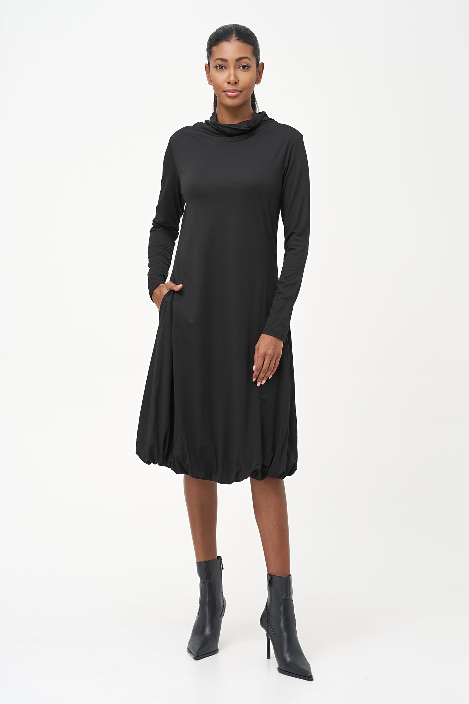 Long sleeve black dress with a soft turtleneck and relaxed A-line silhouette, crafted in stretchy ribbed knit fabric.