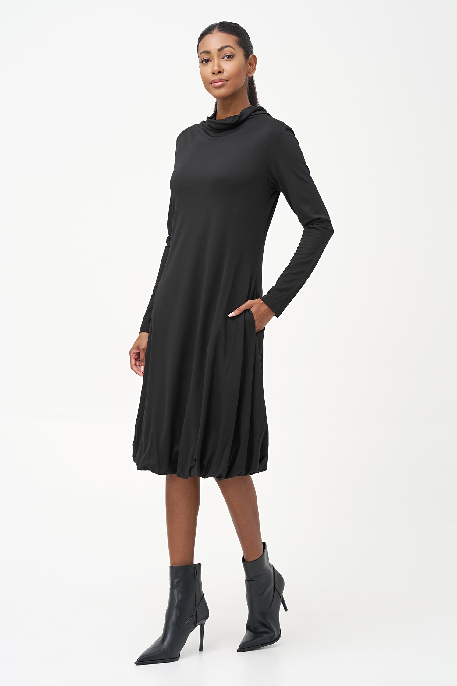 Long sleeve black dress with a soft turtleneck and relaxed A-line silhouette, crafted in stretchy ribbed knit fabric.