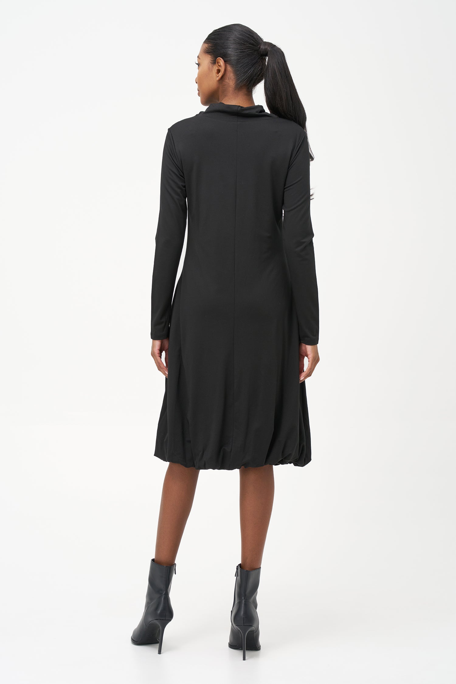 Long sleeve black dress with a soft turtleneck and relaxed A-line silhouette, crafted in stretchy ribbed knit fabric.