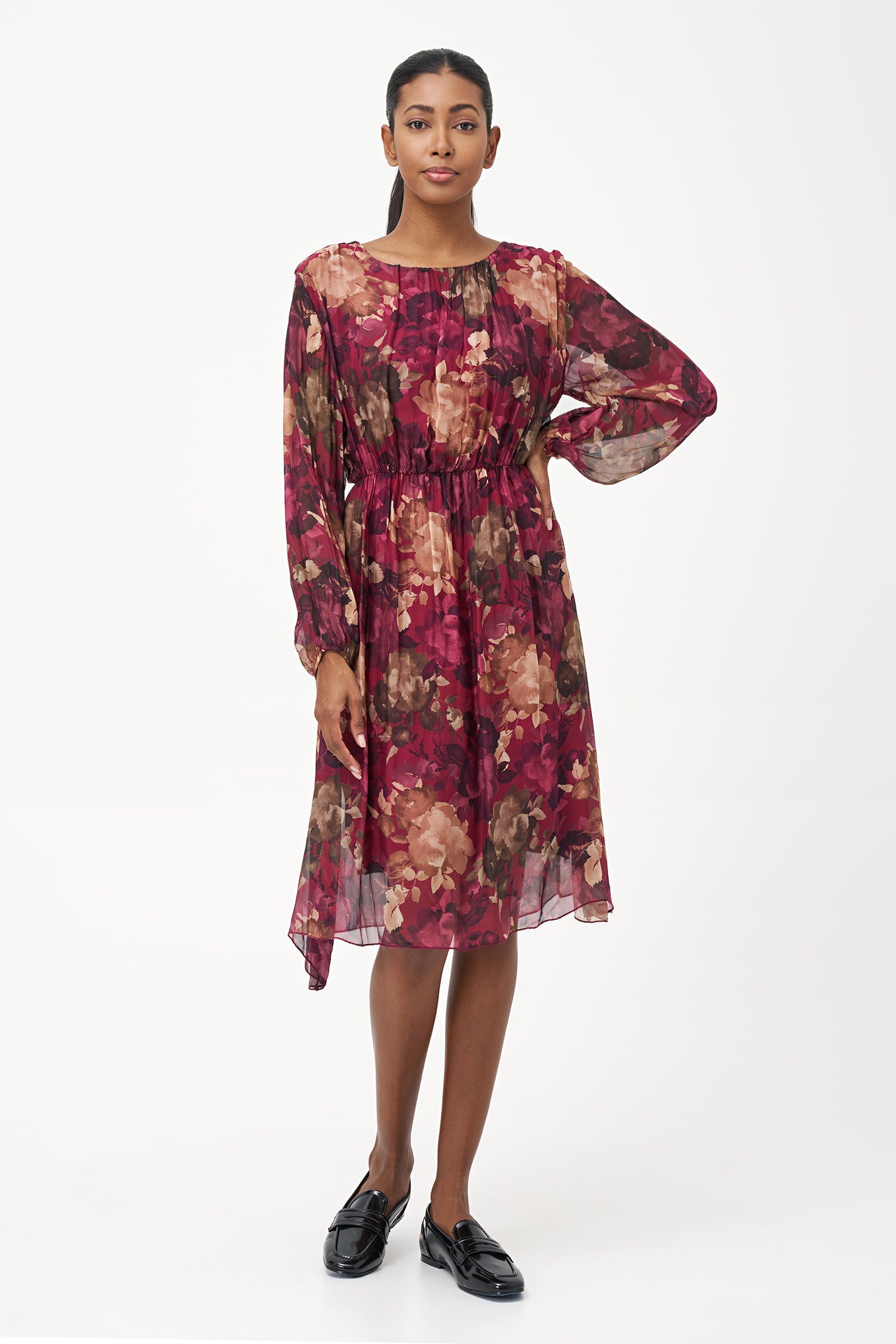 Sheer long-sleeve floral dress in warm earthy tones with gathered neckline and back keyhole detail.