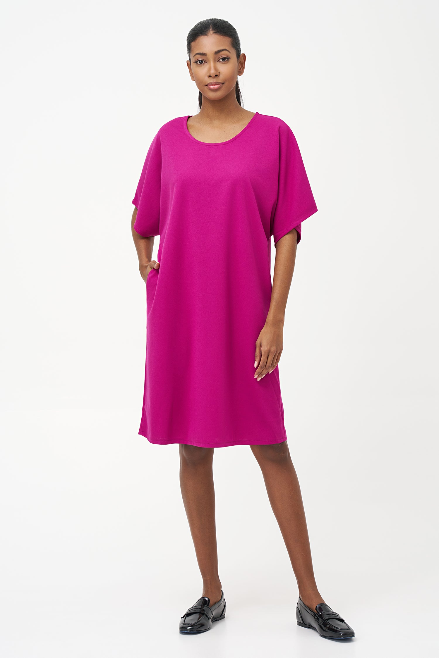 Loose-fit pink knee-length dress with short sleeves and round neckline in soft stretch polyester blend.