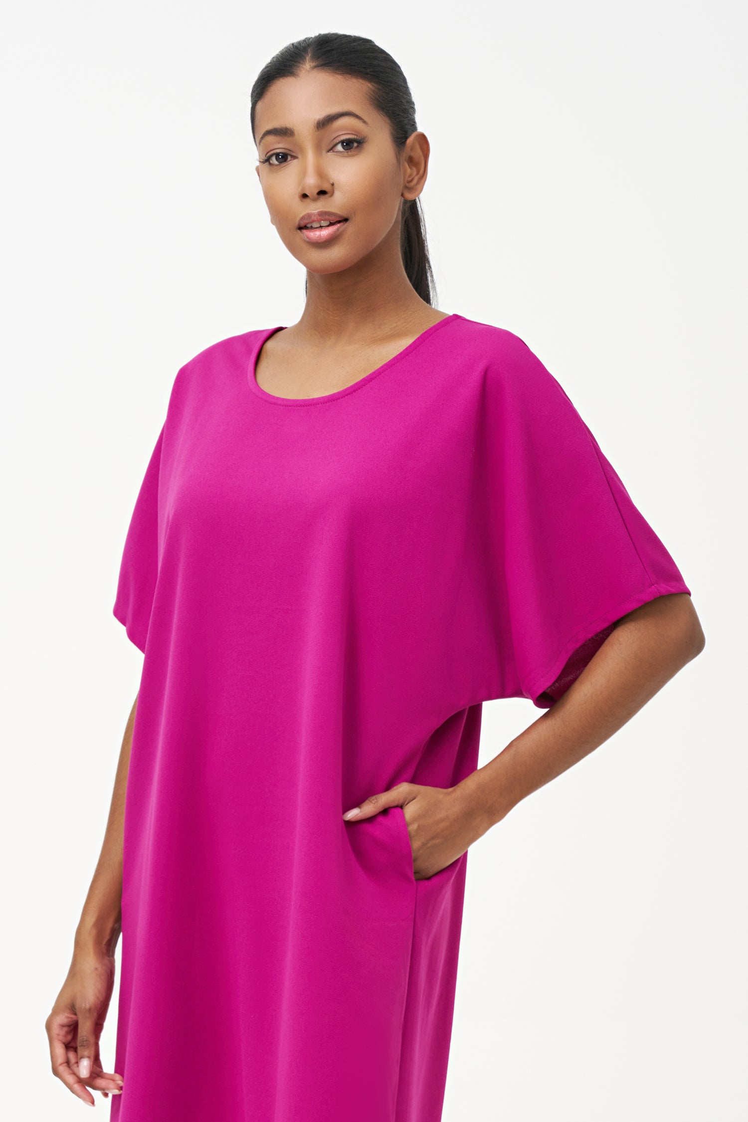 Loose-fit pink knee-length dress with short sleeves and round neckline in soft stretch polyester blend.