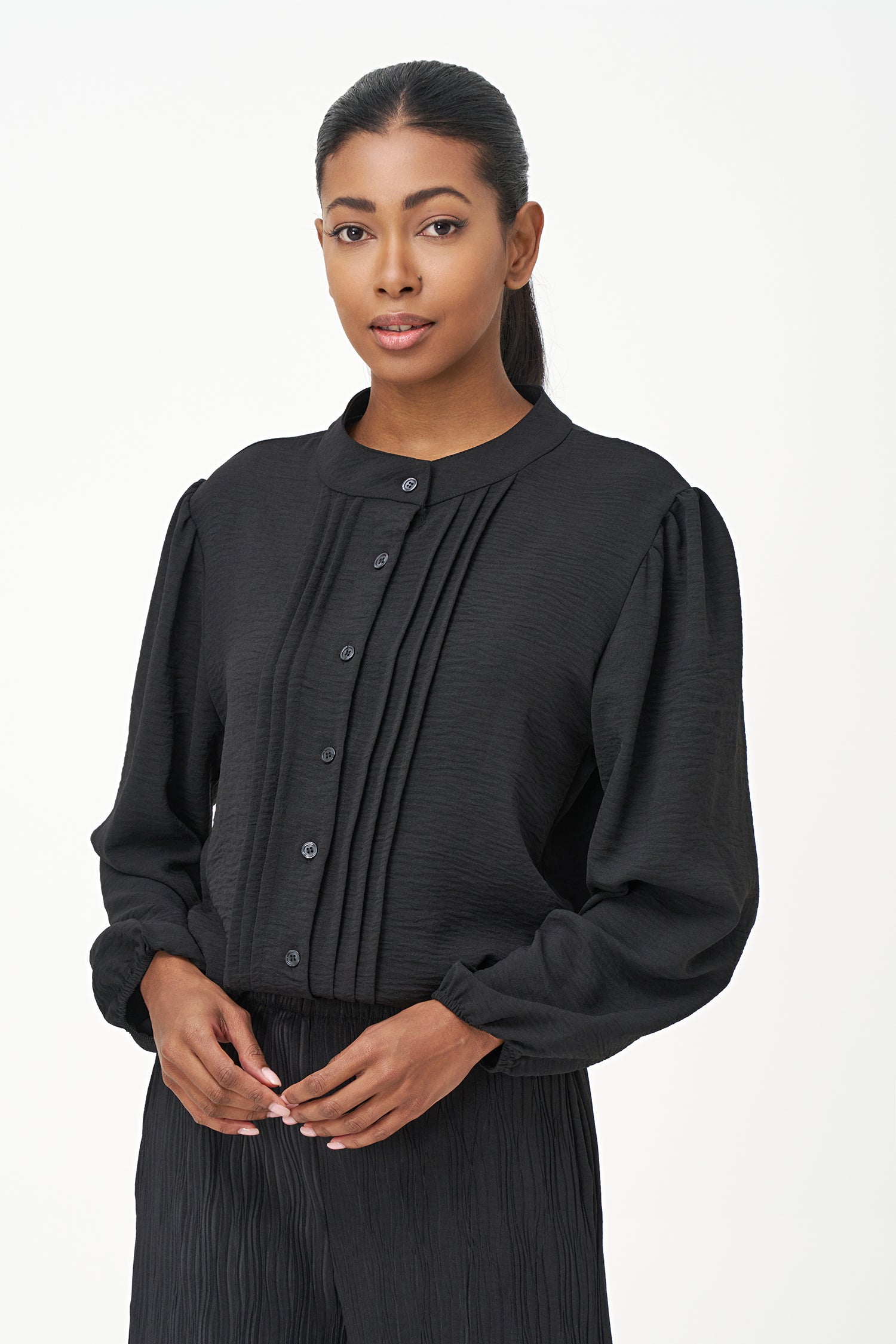 Black long-sleeve blouse with pleated front detail and button-up closure