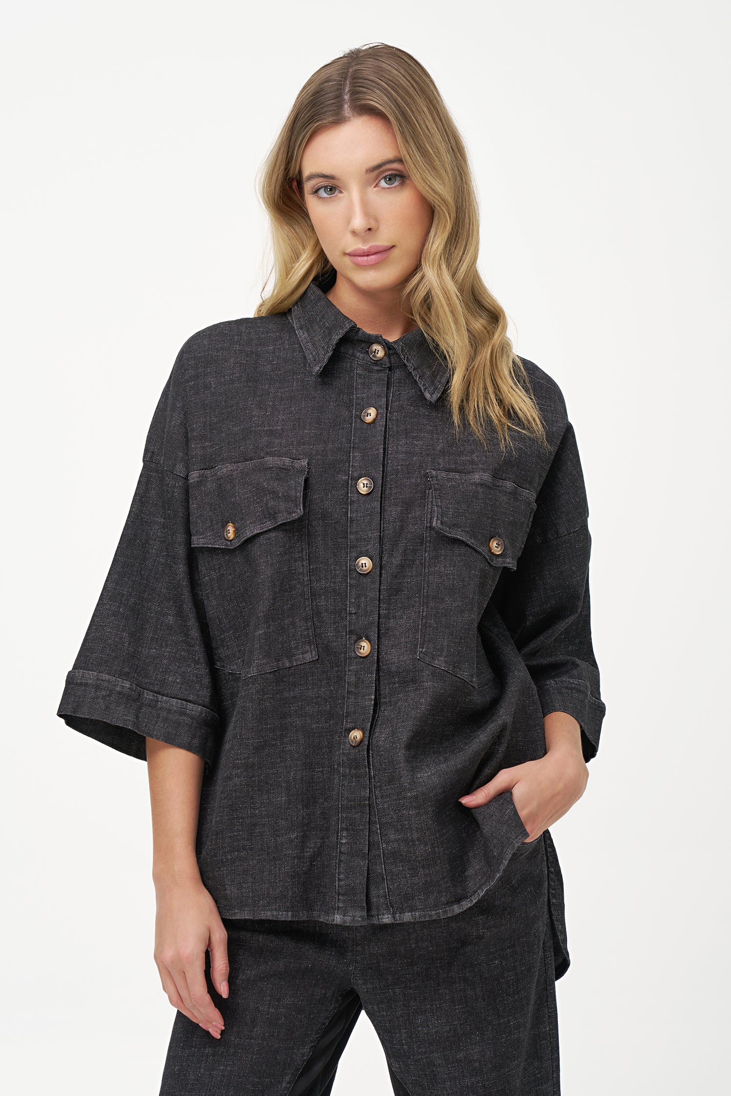 Black denim shirt with wooden buttons, front flap pockets, and 3/4 sleeves