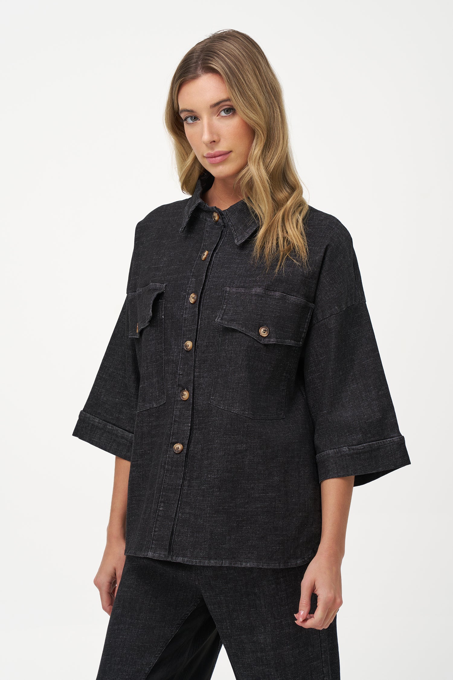 Black denim shirt with wooden buttons, front flap pockets, and 3/4 sleeves