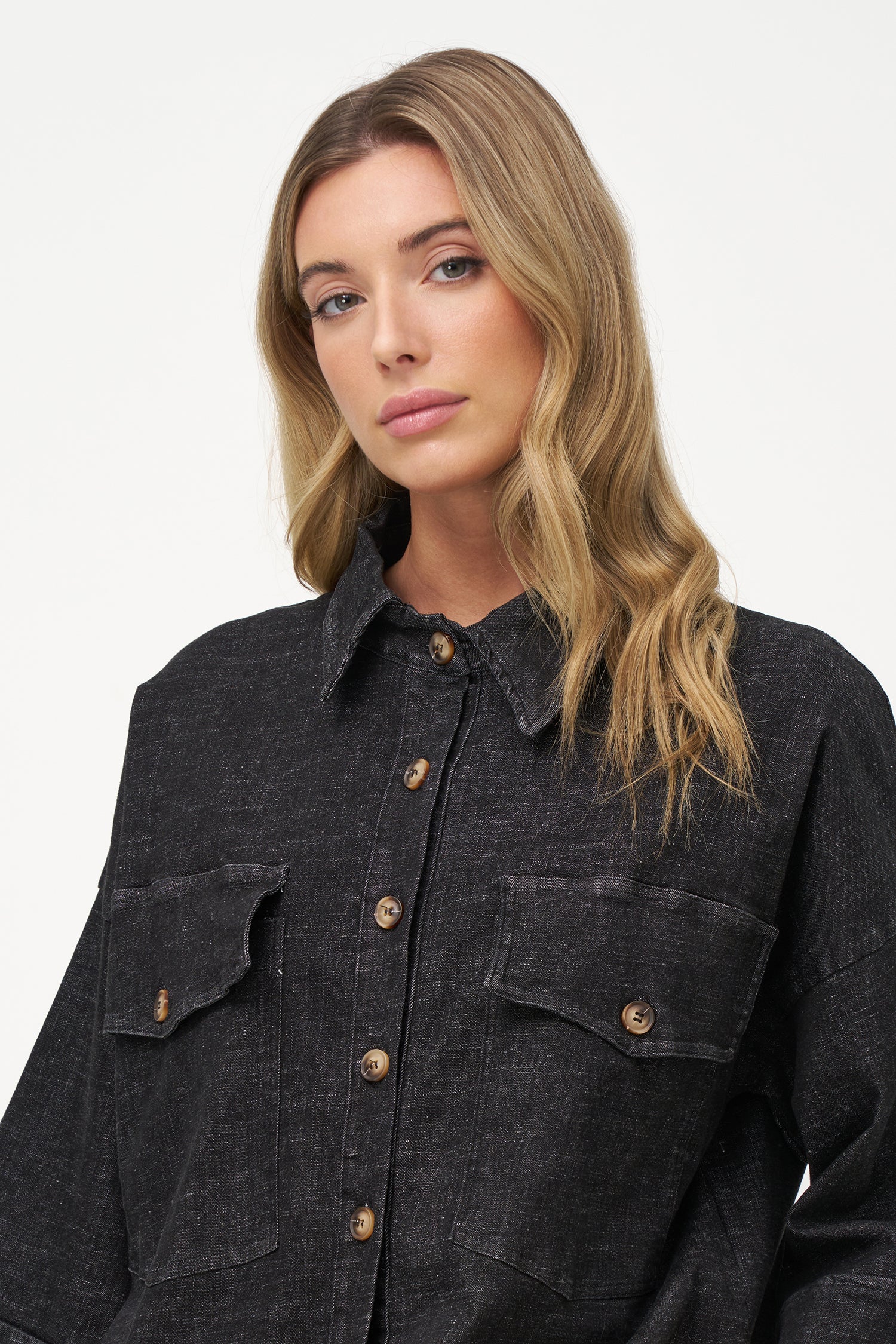 Black denim shirt with wooden buttons, front flap pockets, and 3/4 sleeves