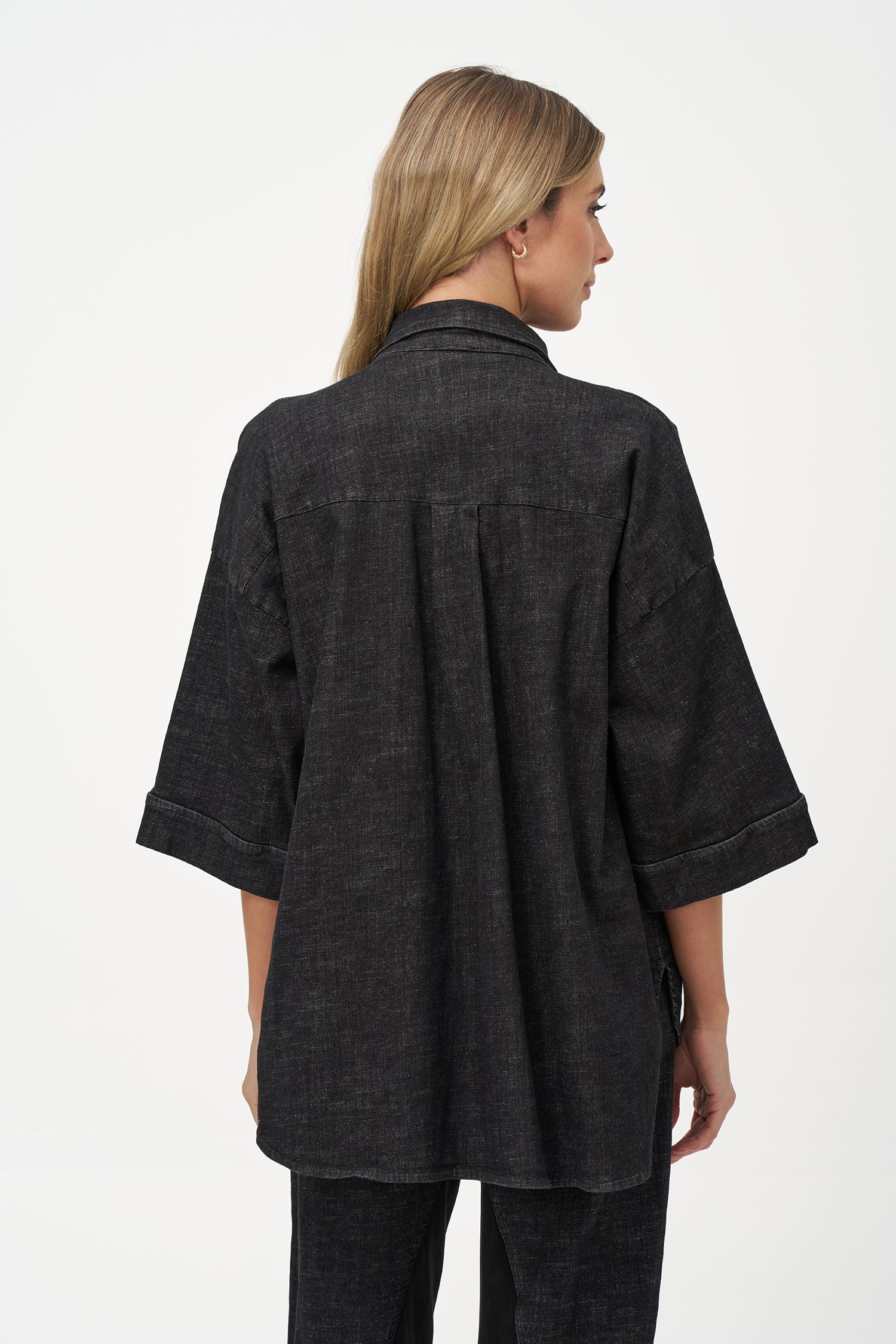 Black denim shirt with wooden buttons, front flap pockets, and 3/4 sleeves