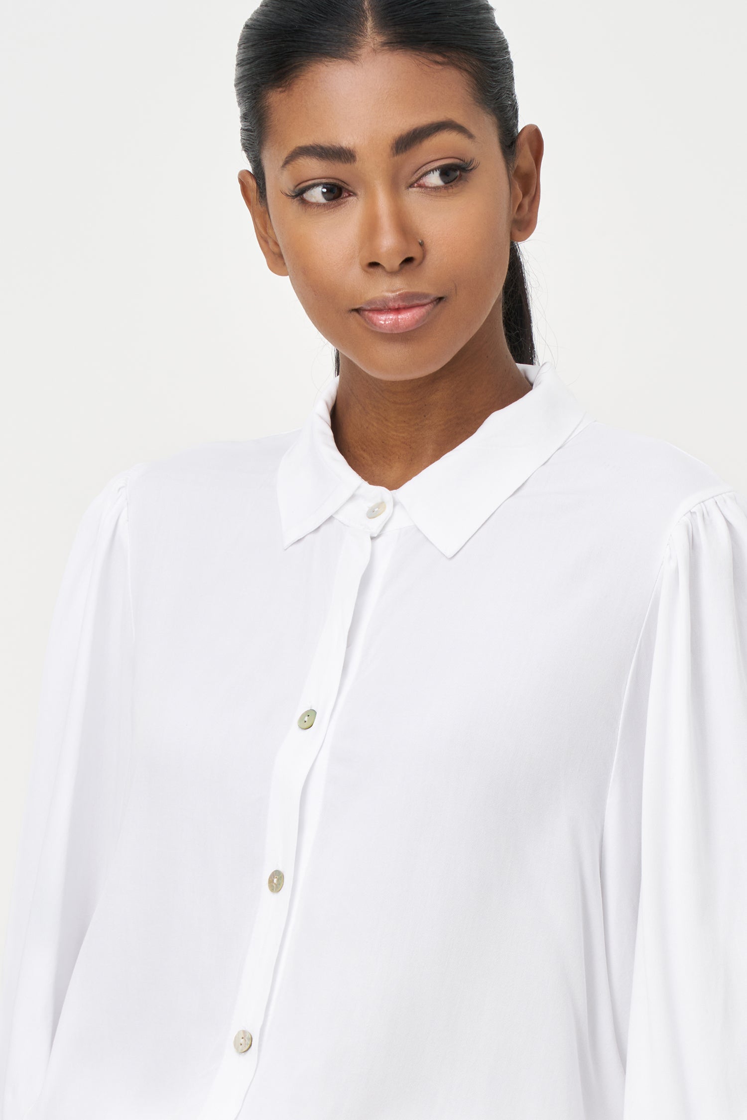 White button-up blouse with relaxed fit, long sleeves, and soft drape