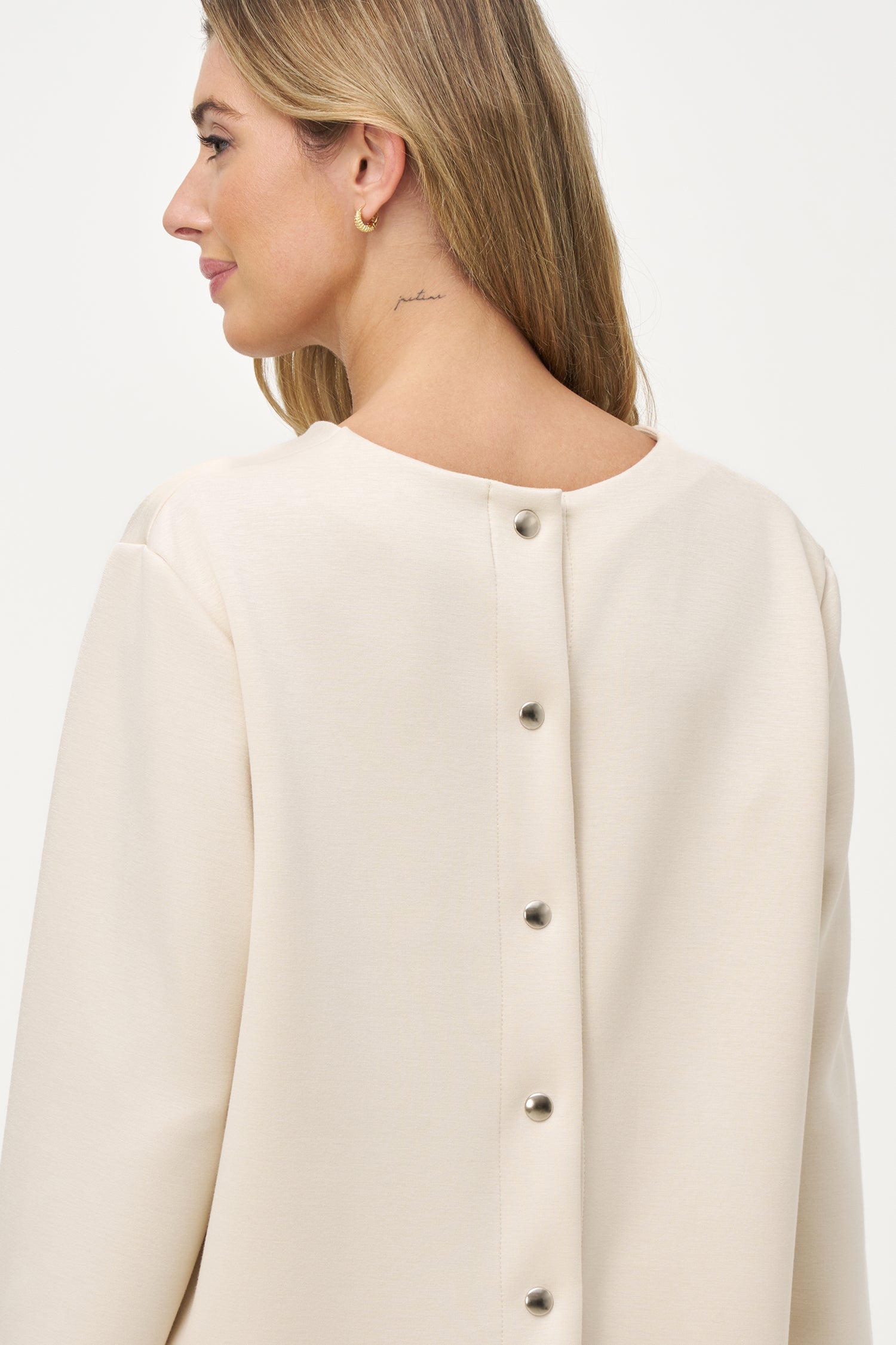 White long sleeve blouse with round neckline and back button closure