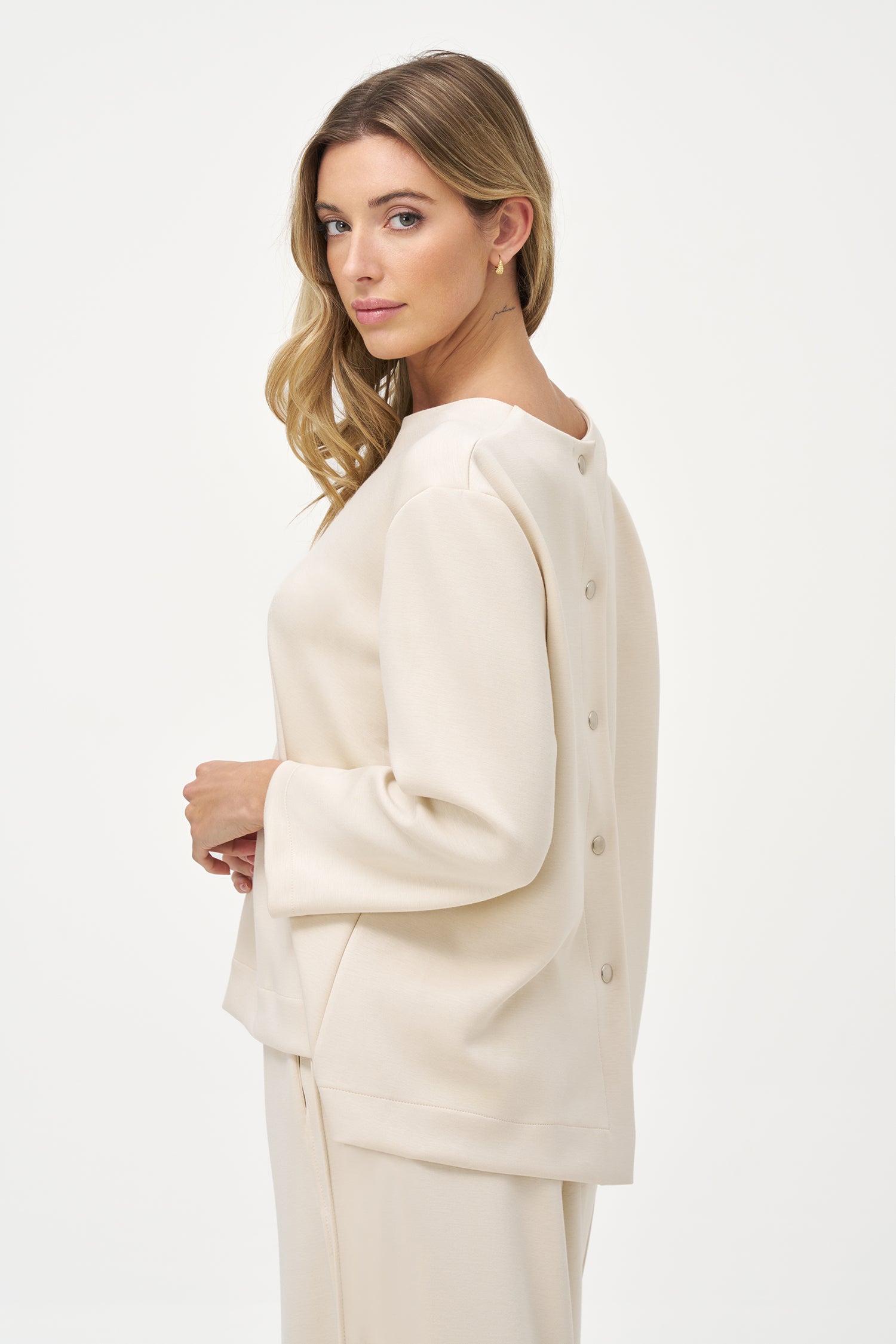 White long sleeve blouse with round neckline and back button closure