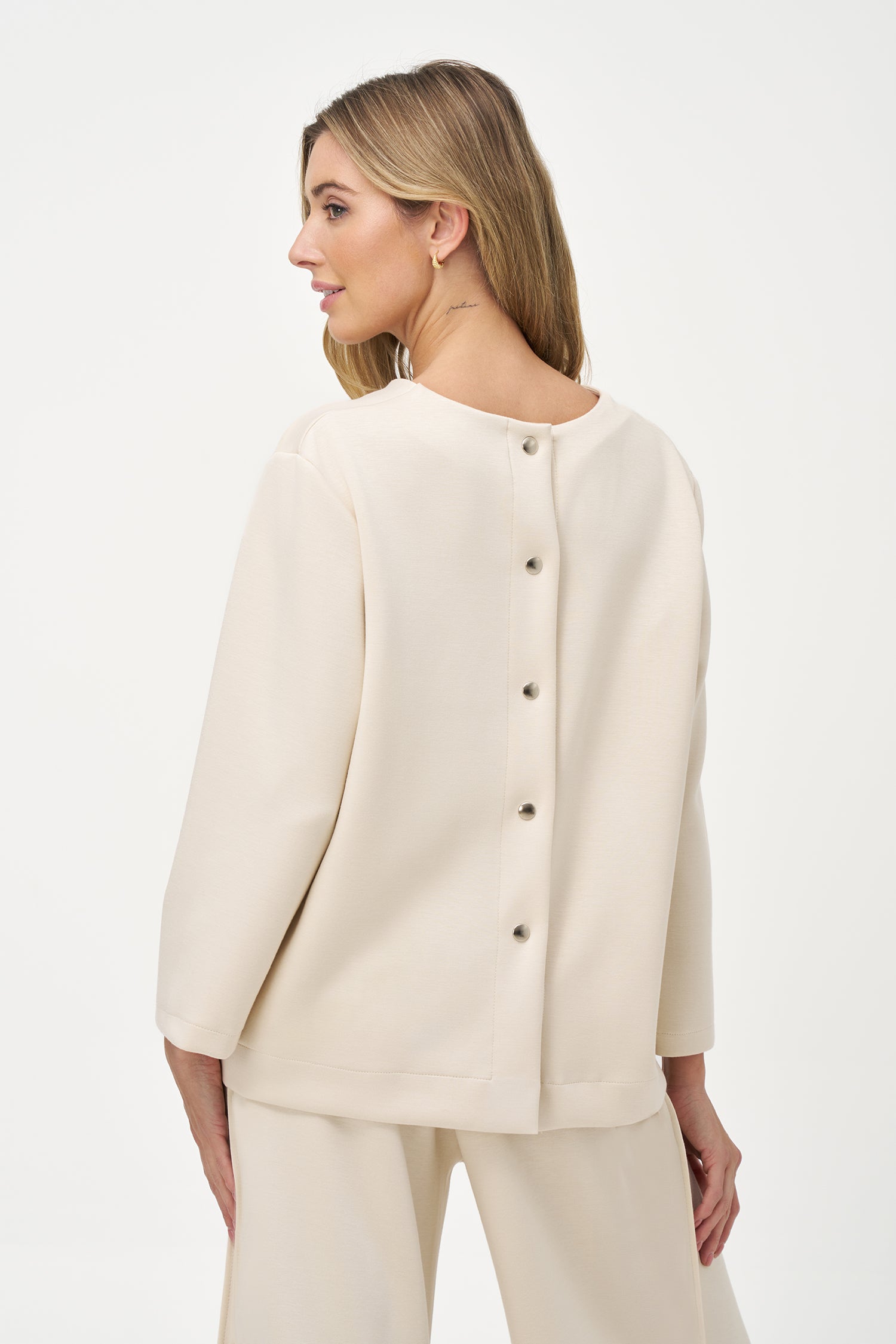 White long sleeve blouse with round neckline and back button closure