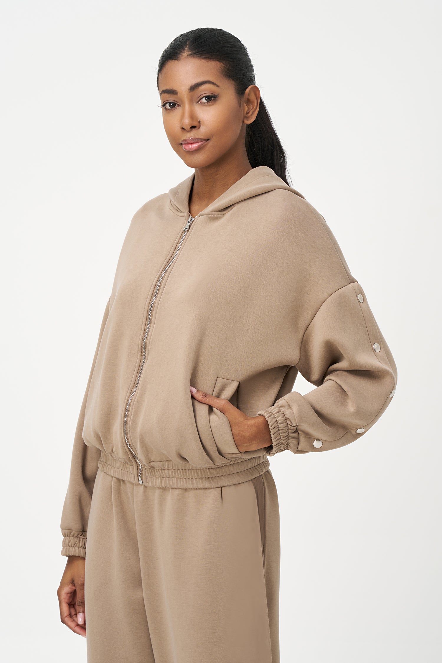 Beige zip-up hoodie with snap button sleeves and elastic cuffs and hem