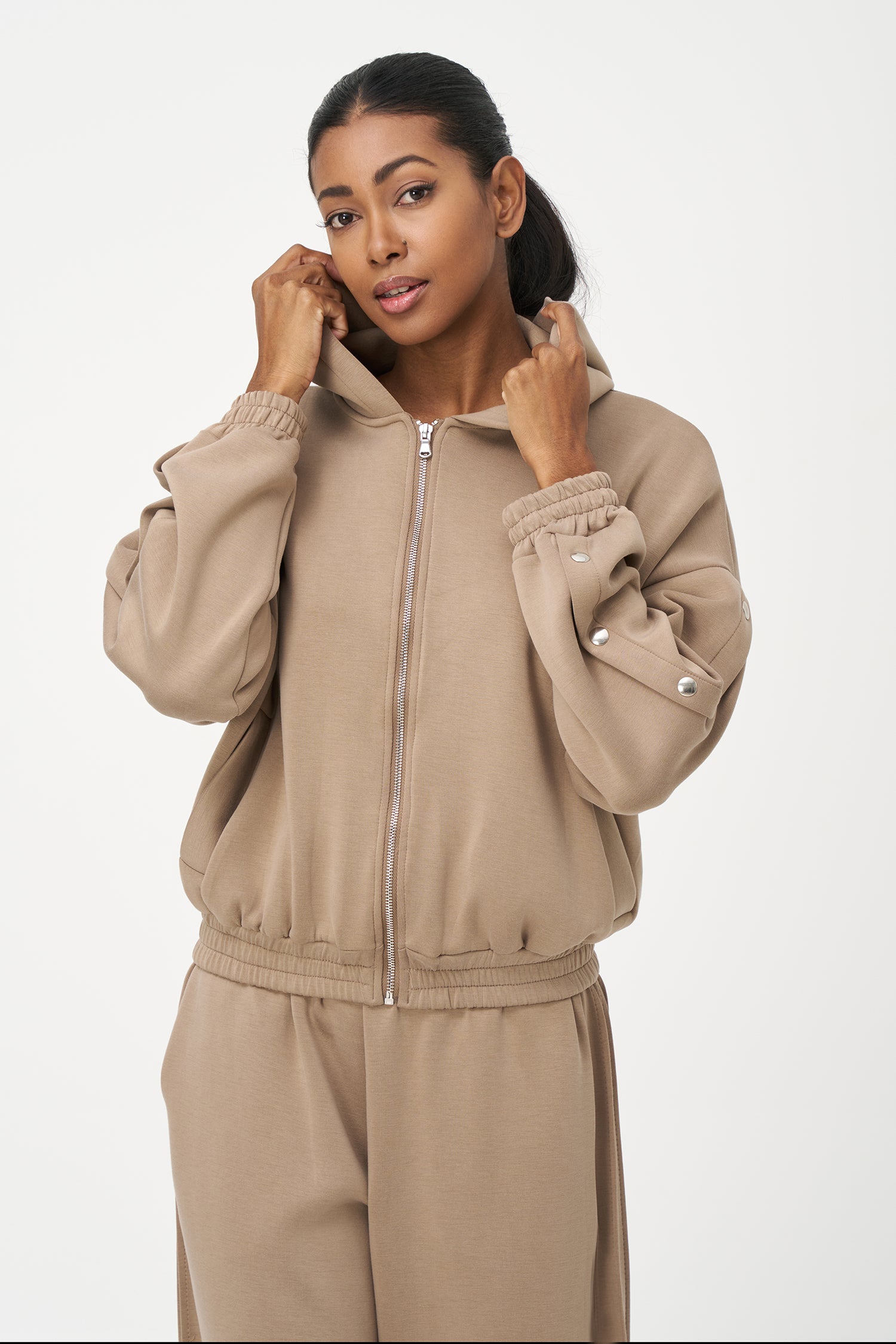 Beige zip-up hoodie with snap button sleeves and elastic cuffs and hem